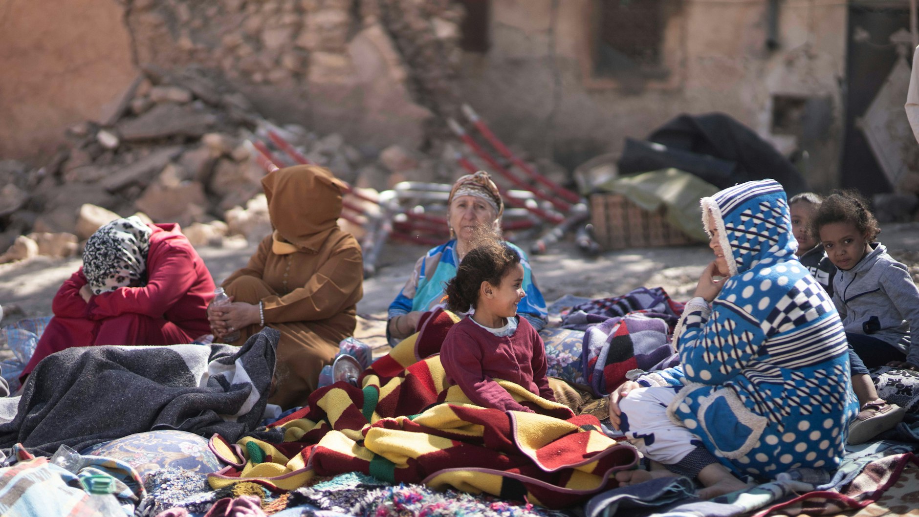 Marrakech: familias sentadas frente a sus casas destruidas.