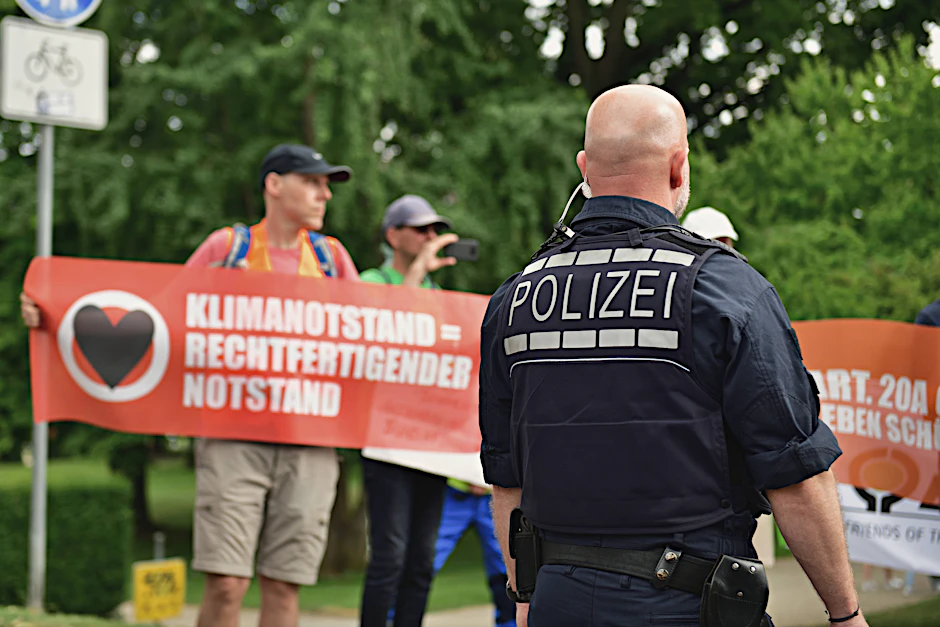 Polizisten lösen eine Straßenblockade der Letzten Generation auf.