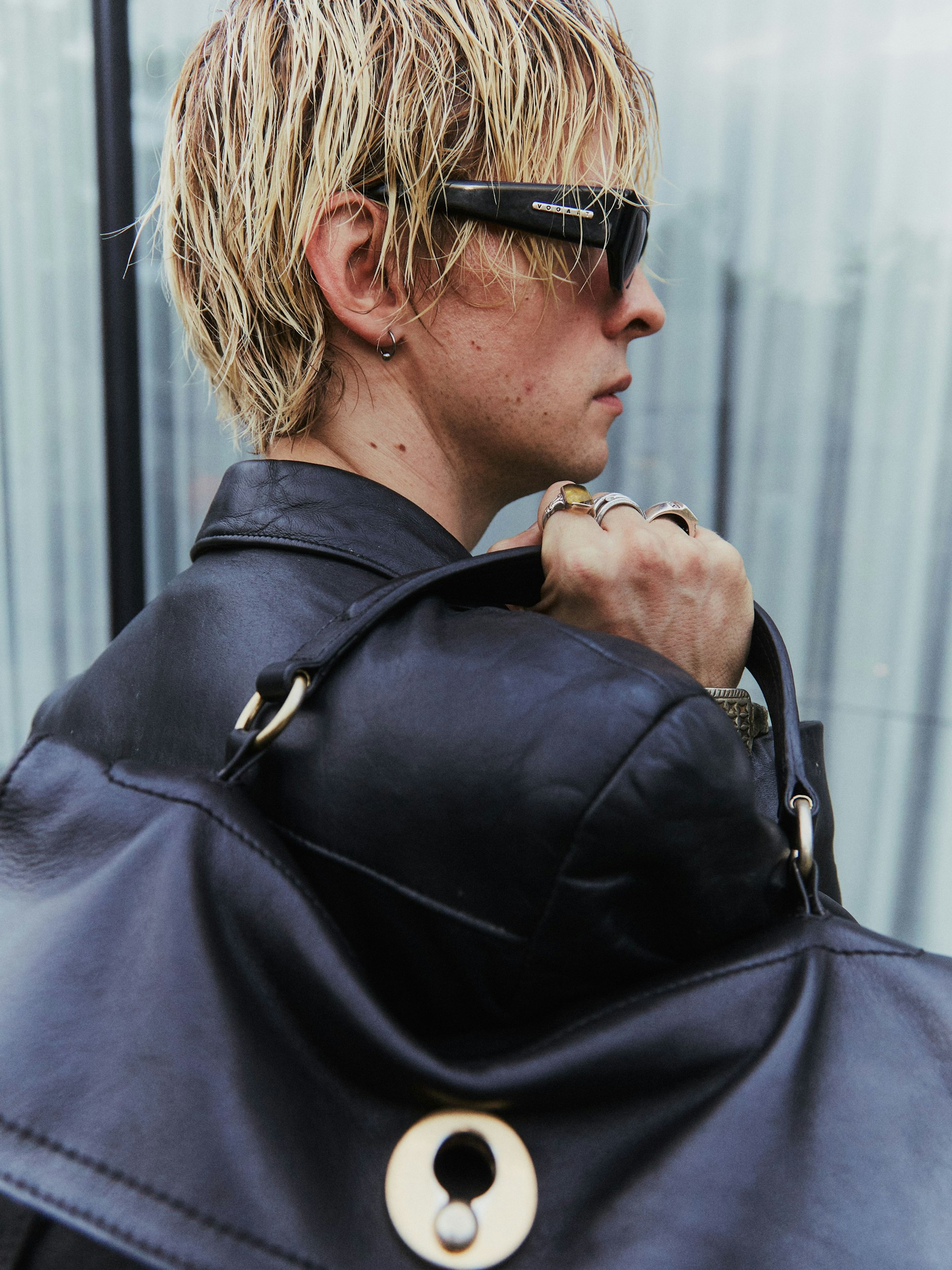 Sein Lederoutfit ist komplett vintage. Darunter trägt er ein T-Shirt von Dior, darüber ganz viel Statement-Schmuck und eine Sonnenbrille von Vogart – eine italienische Brillenmarke, die in den 90er-Jahren angesagt war.