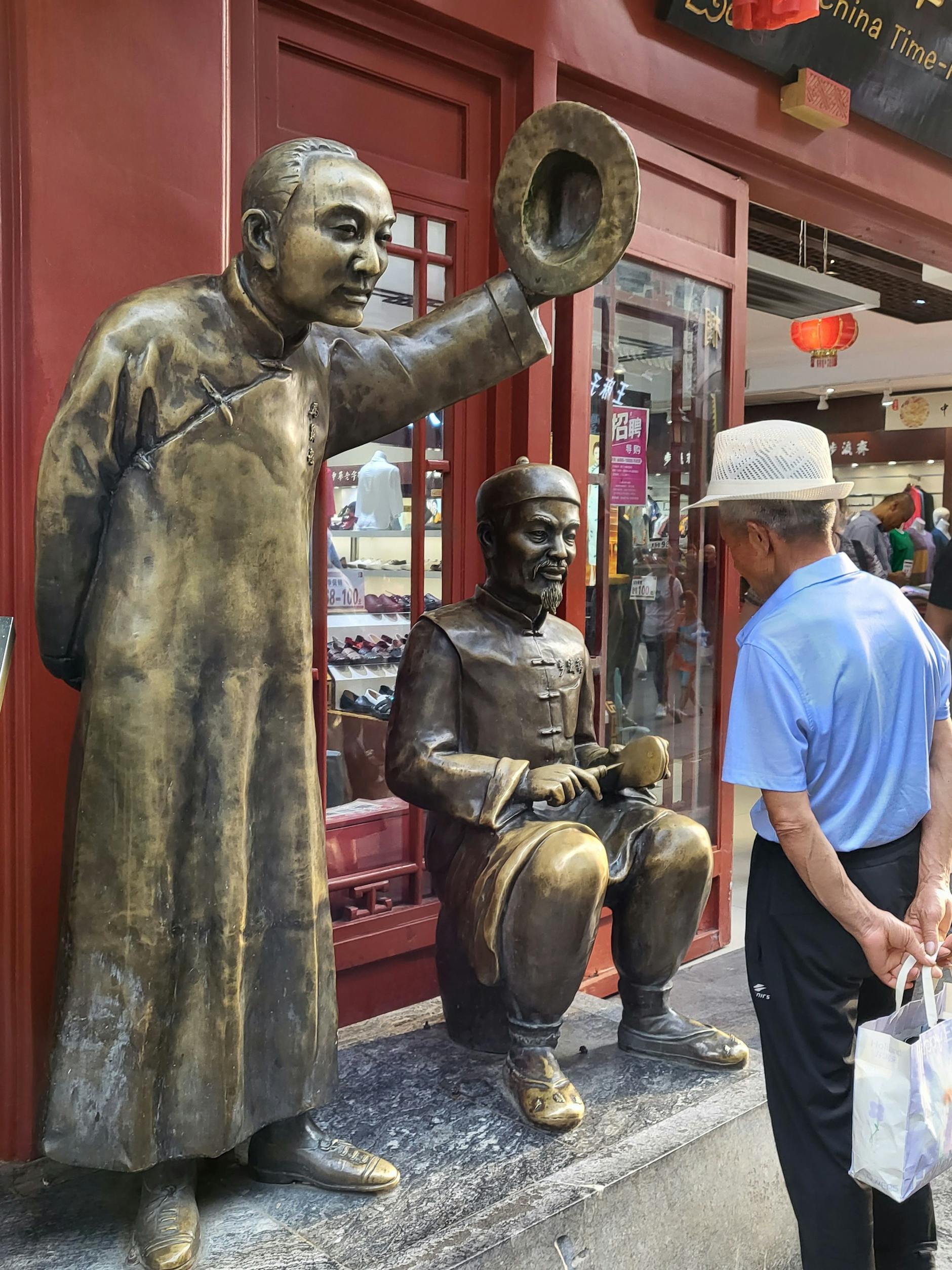 Fußgängerzone in Peking: Zwischen den Geschäften stehen immer wieder Skulpturen mit Figuren aus alten Zeiten.