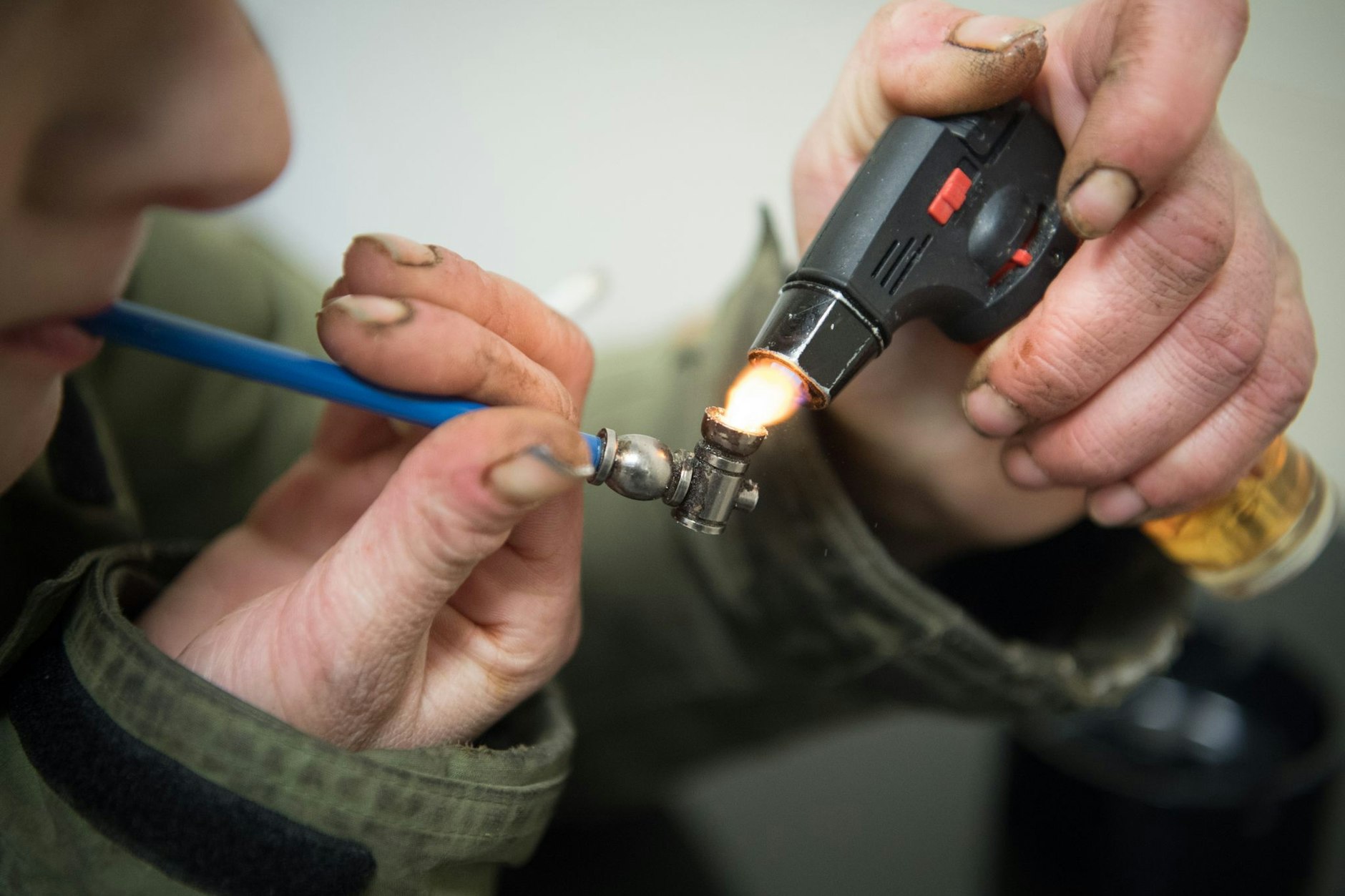 Eine cracksüchtige Frau zündet sich mithilfe eines Gasbrenners einen Crackstein in einer Pfeife an.