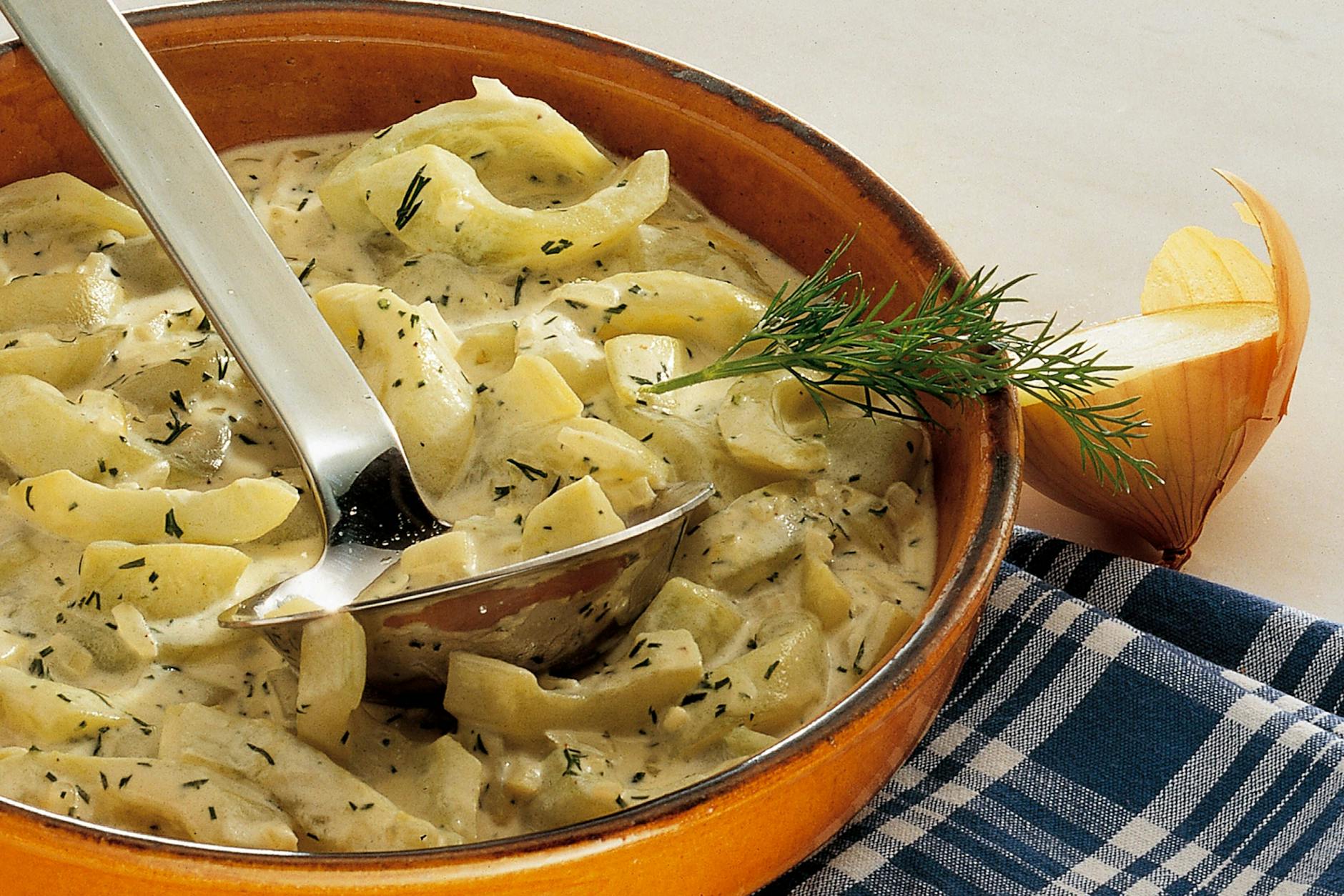 Schmorgurken wie in der DDR in cremiger Soße, serviert in einer Schüssel mit frischem Dill.
