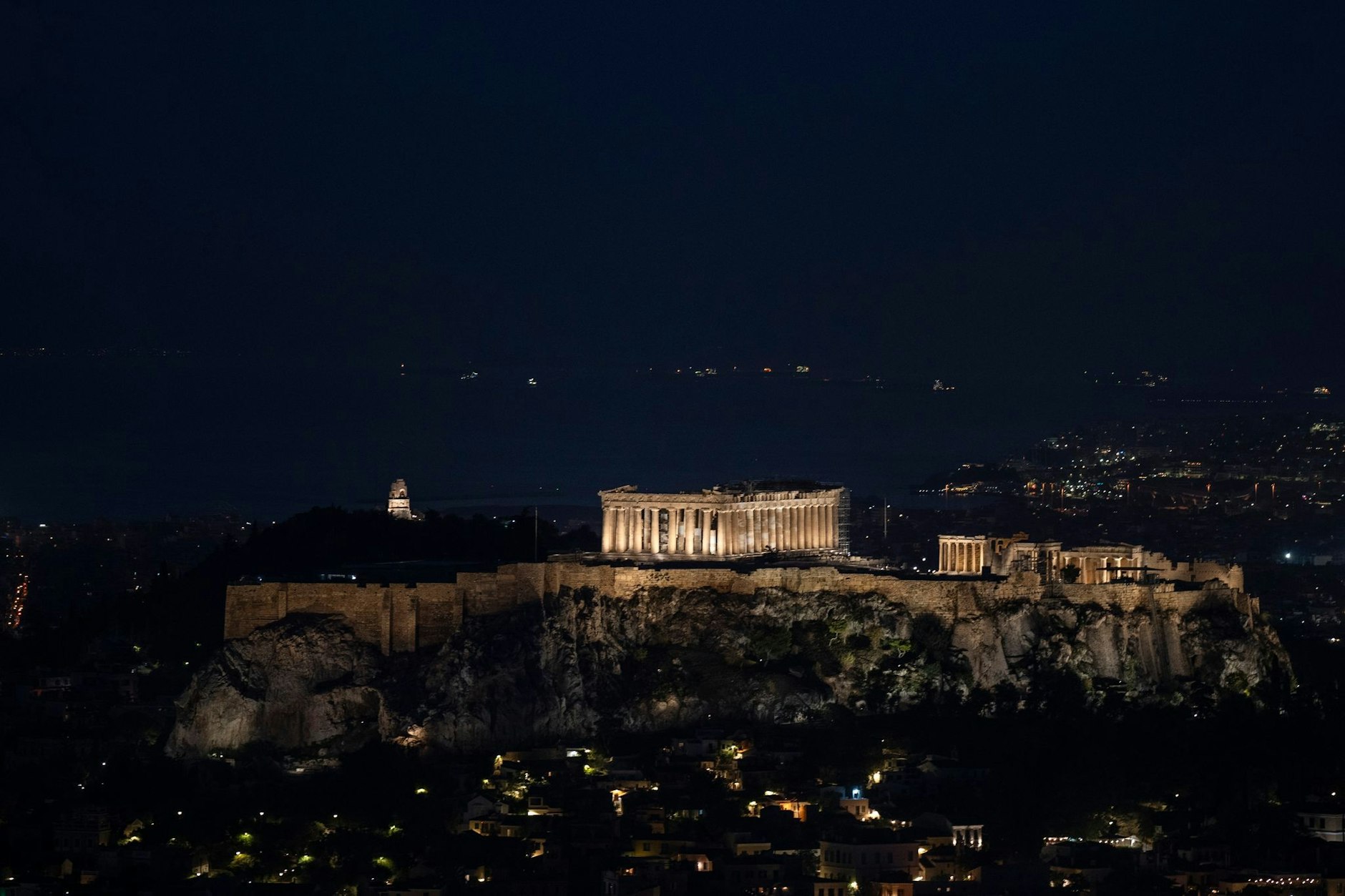 Der antike Akropolis-Hügel wird über der Stadt Athen beleuchtet.  