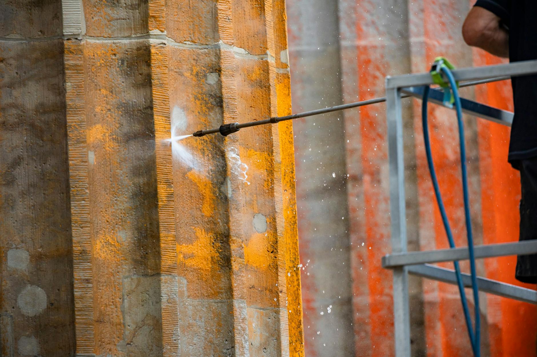Der Sandstein des Brandenburger Tors wird mit der Hilfe von Hochdruckwasser von der Farbe befreit.