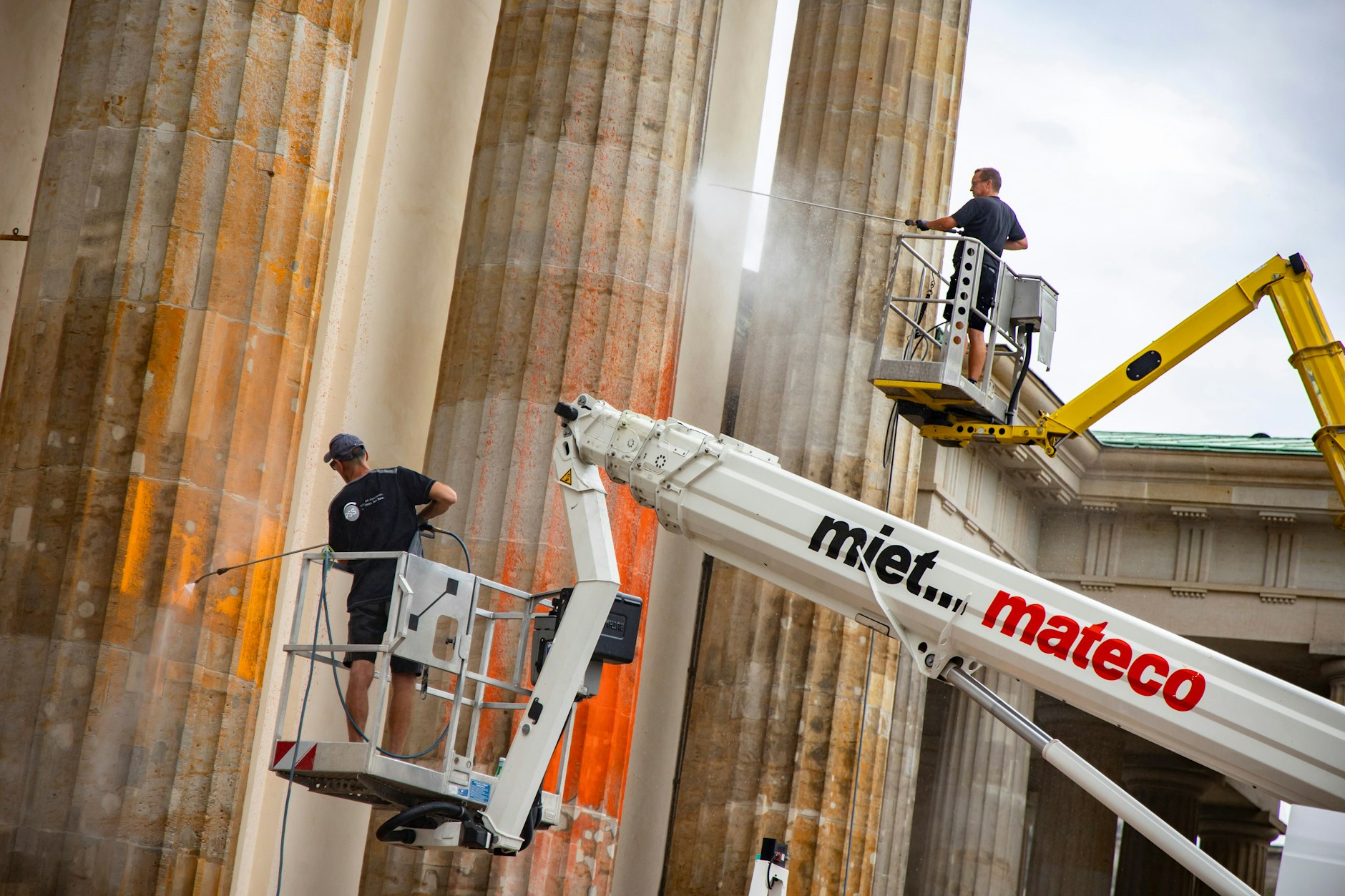 Das Brandenburger Tor muss nun mit Hochdruckwasser gereinigt werden. Dafür sind auch zwei Hebebühnen im Einsatz.