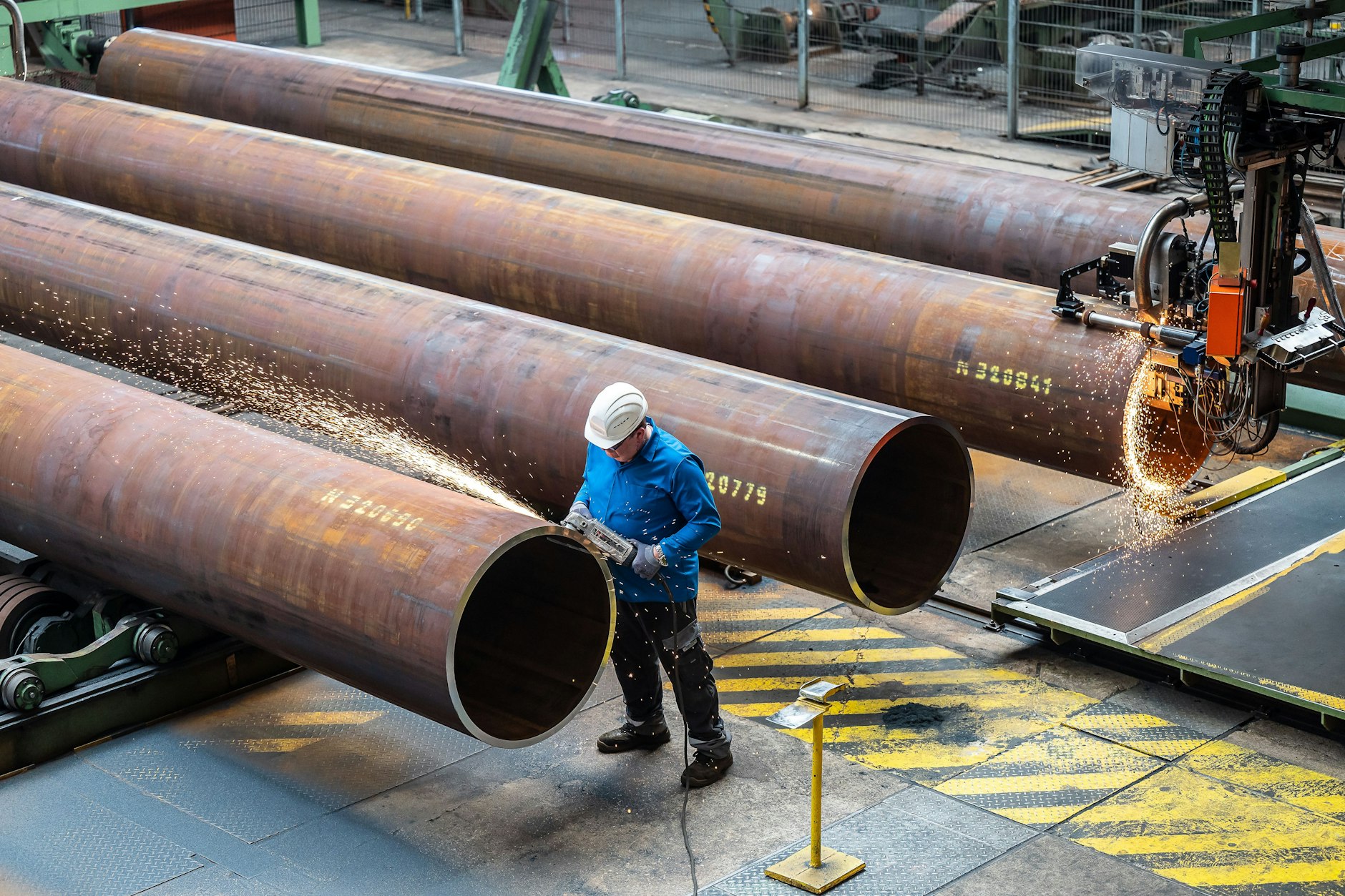 Ein Arbeiter bearbeitet ein Rohr in einer Fabrik in Mülheim an der Ruhr.