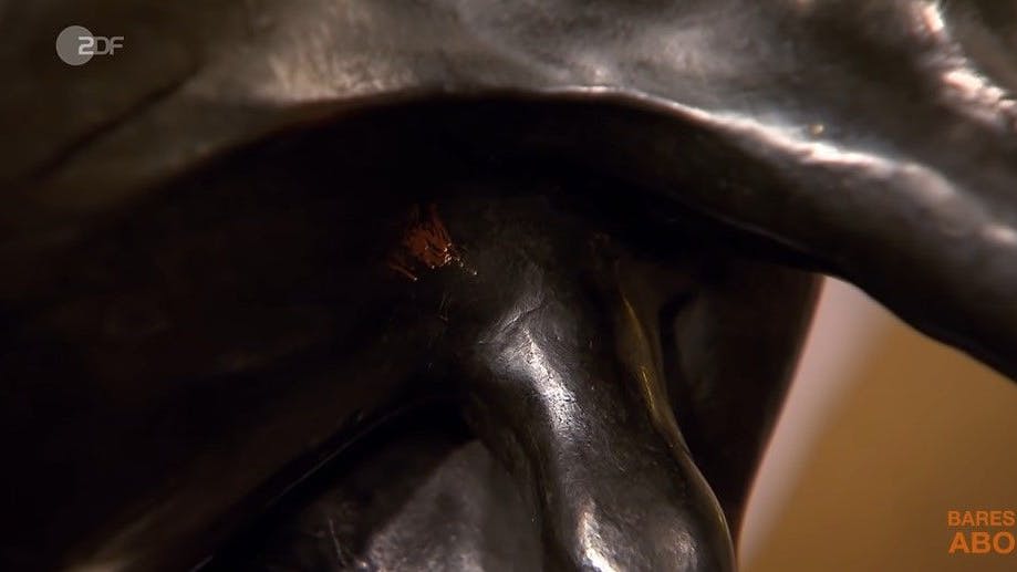 Die „Bares für Rares“-Expertin zeigt eine Kratzstelle am Unterbauch des Stieres, die zeigt, dass es sich um eine Bronze handelt.