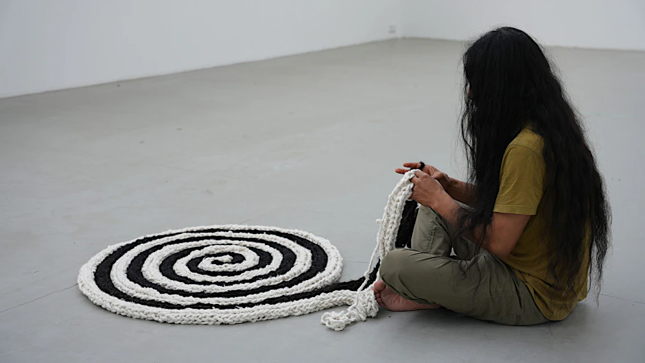 Antonio Paucar&nbsp; in der Berliner Galerie beim Flechten einer symbolstarken Alpaka-Wollspirale&nbsp;&nbsp;
