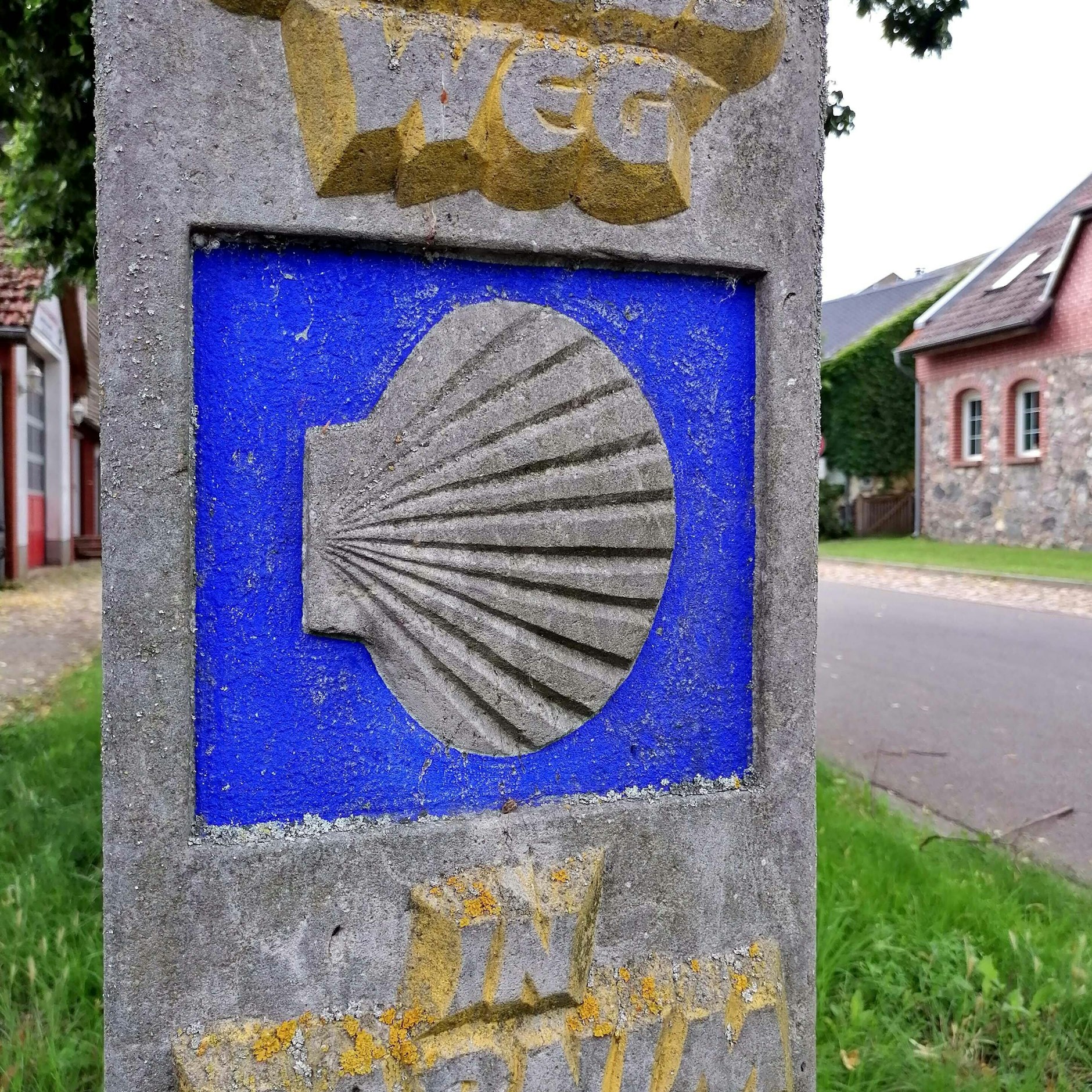 Das Erkennungszeichen eines Pilgerweges ist die Jakobsmuschel wie hier in Löme