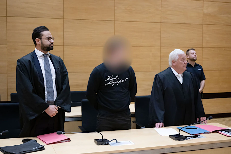Der Angeklagte (M) und seine Verteidiger im Gerichtssaal im Landgericht Bielefeld.  