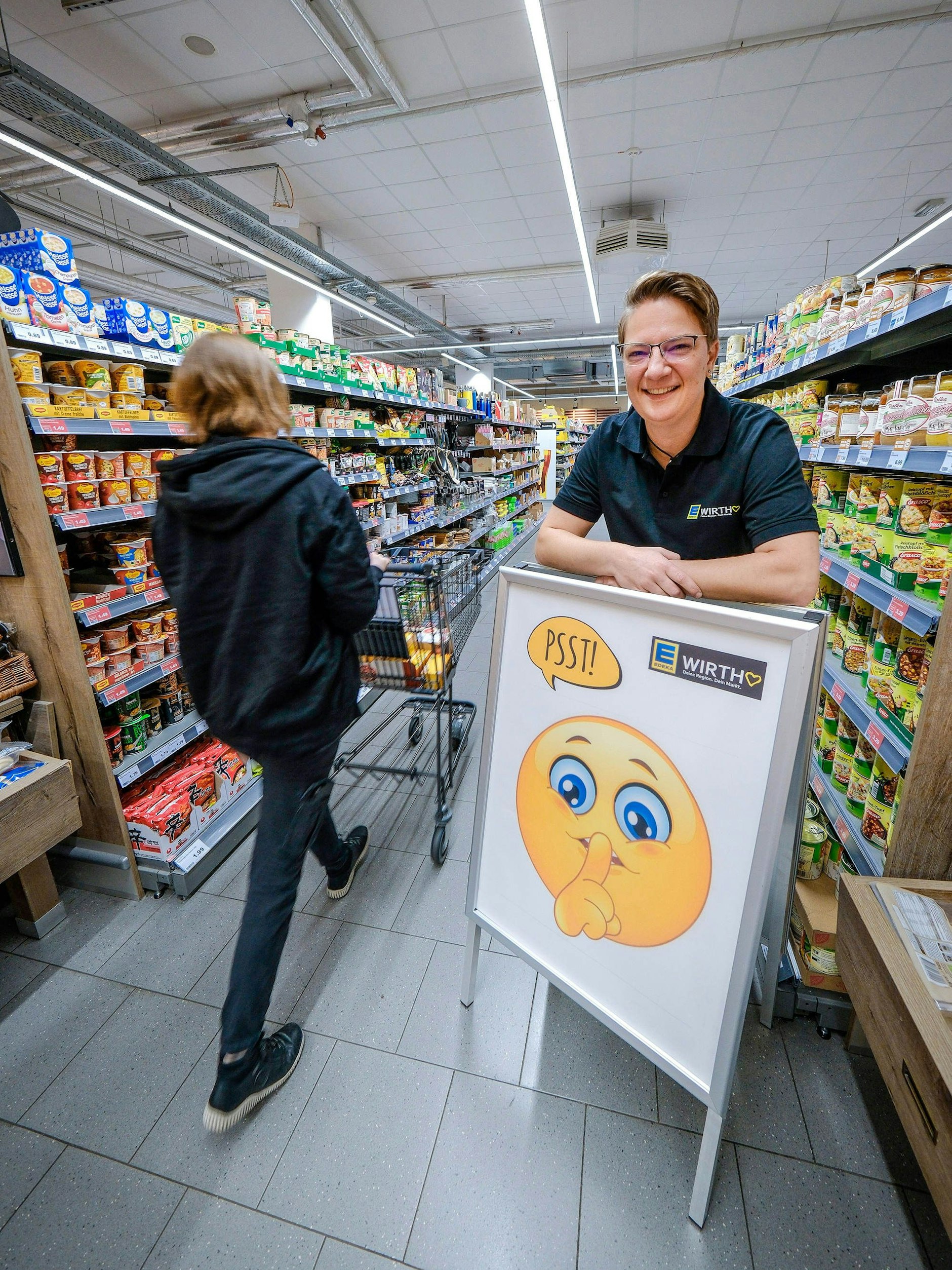 Nadja Wirth, Inhaberin der Edeka-Filiale am Herrenhäeuser Markt in Hannover, mit ihrem Aufsteller zur „Stillen Stunde“.