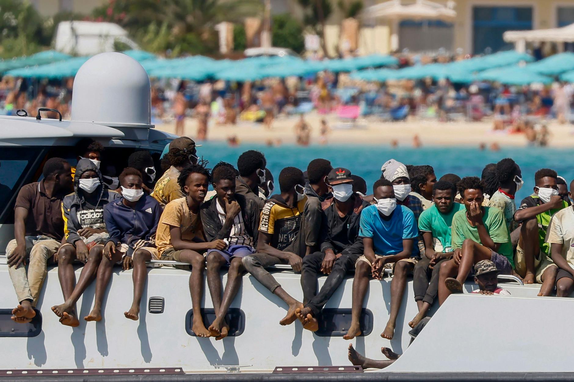 Migranten auf dem Deck eines Schiffes der italienischen Küstenwache, das sie zur Insel Lampedusa bringt