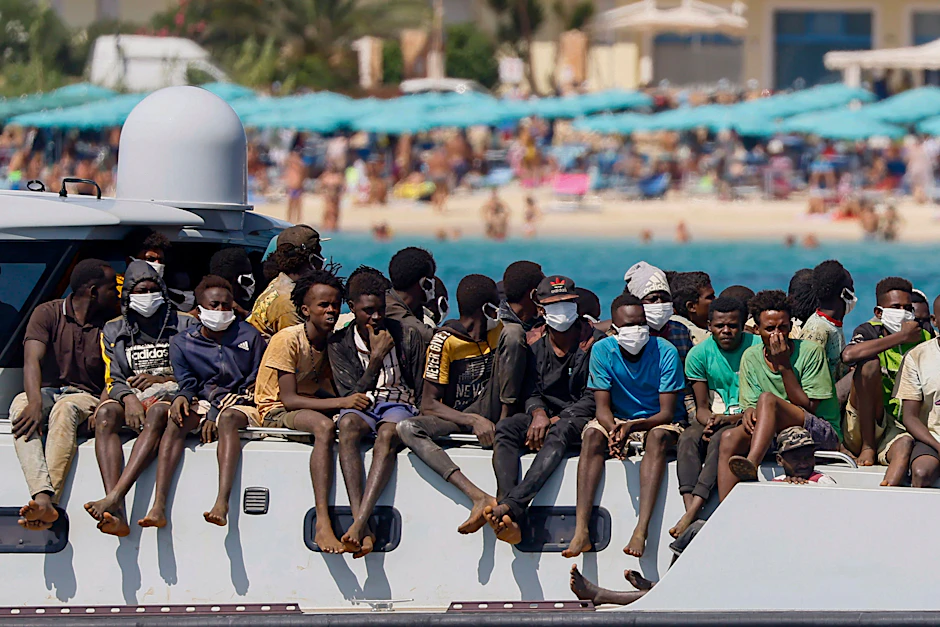 Migranten auf dem Deck eines Schiffes der italienischen Küstenwache, das sie zur Insel Lampedusa bringt