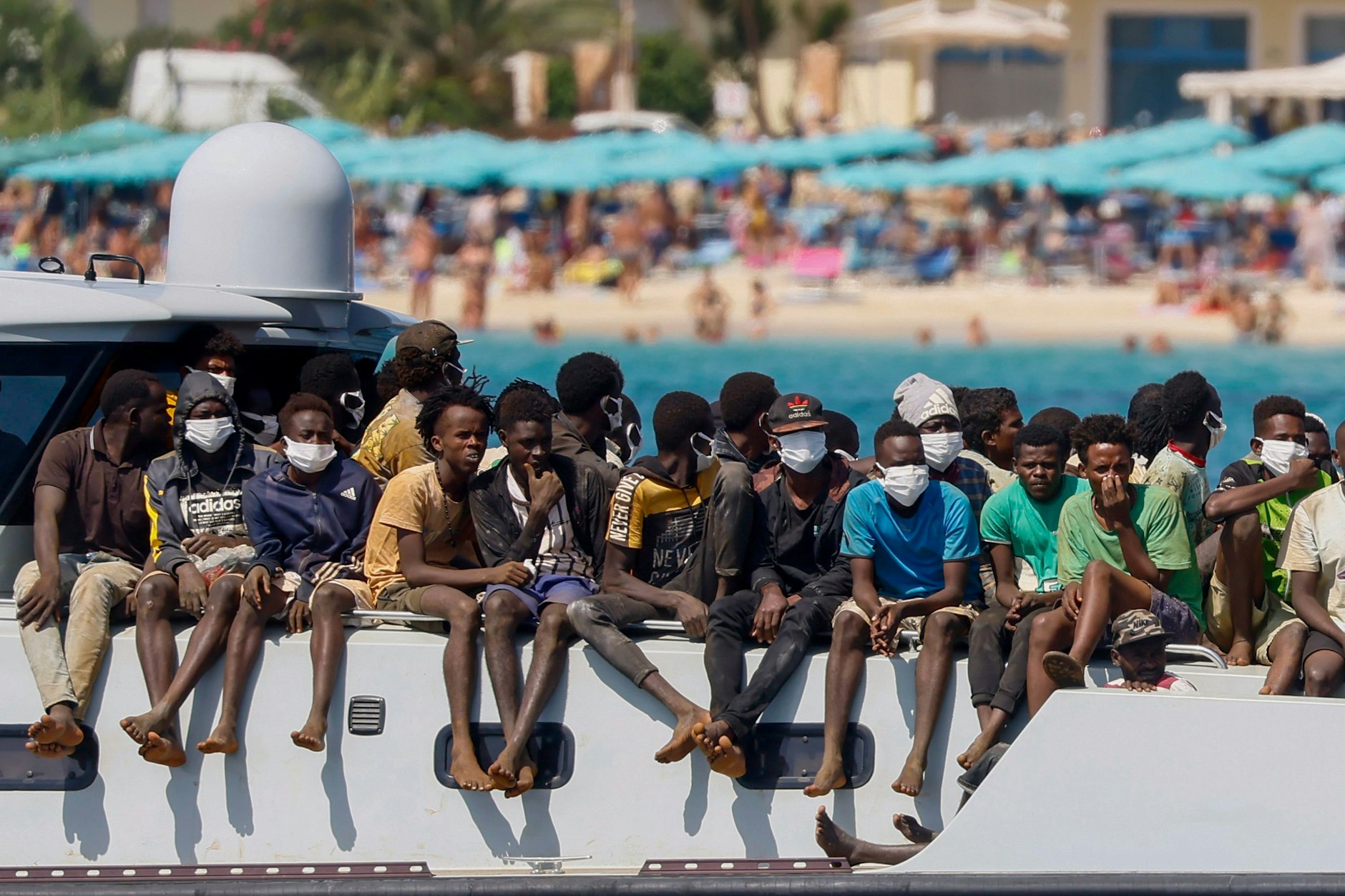 Migranten auf dem Deck eines Schiffes der italienischen Küstenwache, das sie zur Insel Lampedusa bringt