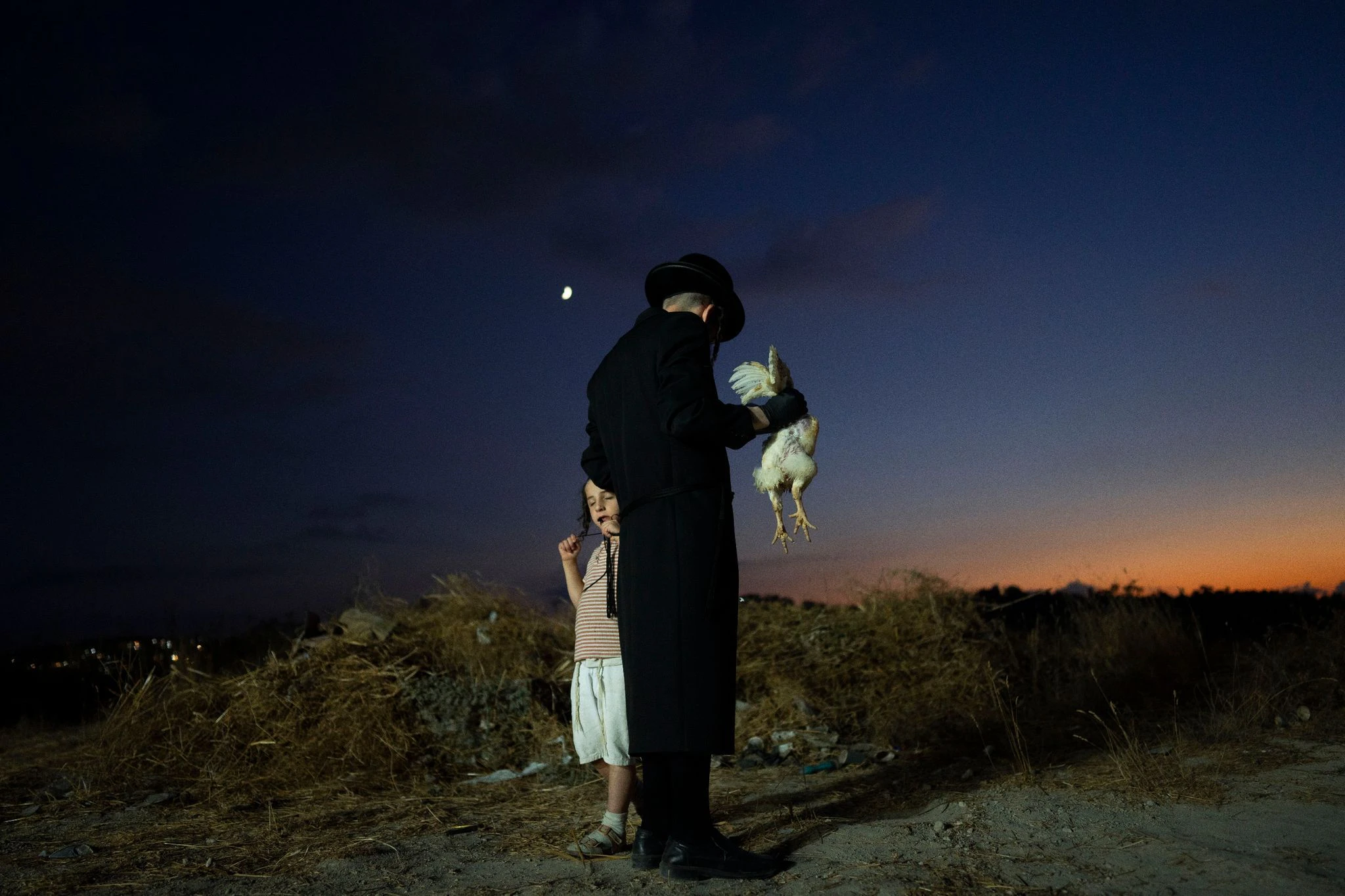 Ein orthodox-jüdischer Mann begeht im israelischen Beit Schemesch das Kapparot-Ritual. Am Vorabend von Jom Kippur wird als Symbol der Sühne ein lebendes Huhn über dem Kopf einer Person geschwenkt und dann geschlachtet.  