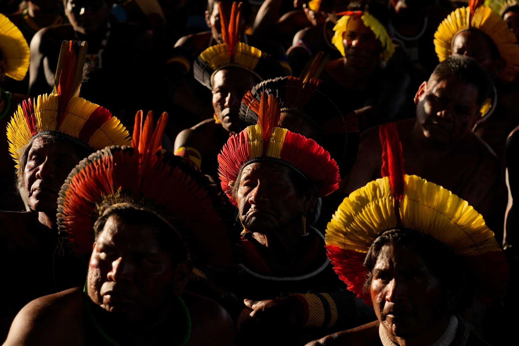Indigene Menschen verfolgen auf einem großen Fernsehbildschirm in Brasilia, wie sich der Oberste Gerichtshof auf eine Entscheidung über die Rechtmäßigkeit von Grenzen riesiger indigener Gebiete vorbereitet.  