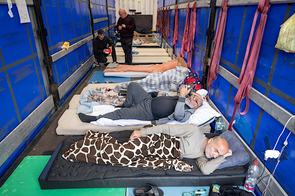 dpatopbilder - Trucker aus Georgien liegen auf einem Matratzenlager auf der Ladefläche eines Lkw. Sie sind in einen Hungerstreik getreten.  