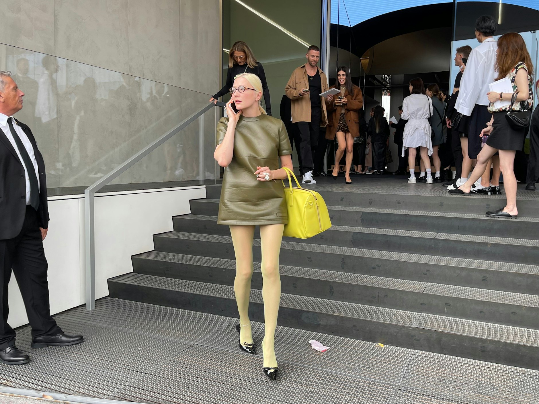 Die russische Stylistin Lotta Volkova arbeitet mit dem Who’s who der internationalen Fashionbranche zusammen. Unter anderem stylt sie die Models auf den Schauen von Miu Miu. Zur Prada-Show erschien sie mit iPhone, einem Lederkleid und einer Brille von Miu Miu sowie Schuhen und Tasche von Prada.