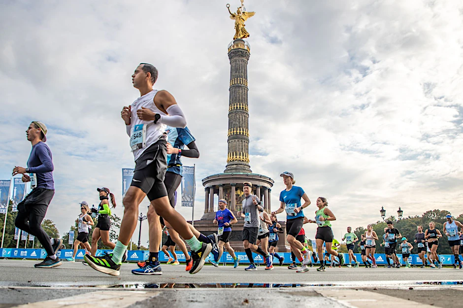 ARCHIV - Die Läufer der ersten Welle des BMW Berlin Marathon passieren auf der Straße des 17. Juni die Siegessäule.  