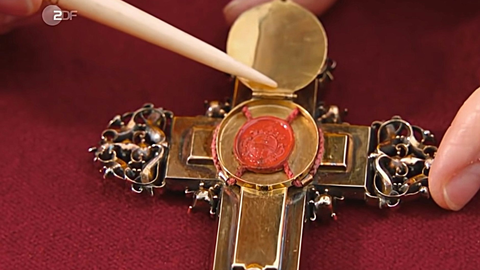 Hinter dem Decken an der Rückseite des Schmuckstückes verbergen sich Holzsplitter aus dem Kreuz Jesu Christi. Bei „Bares für Rares“ kam das Kreuz unter den Hammer.
