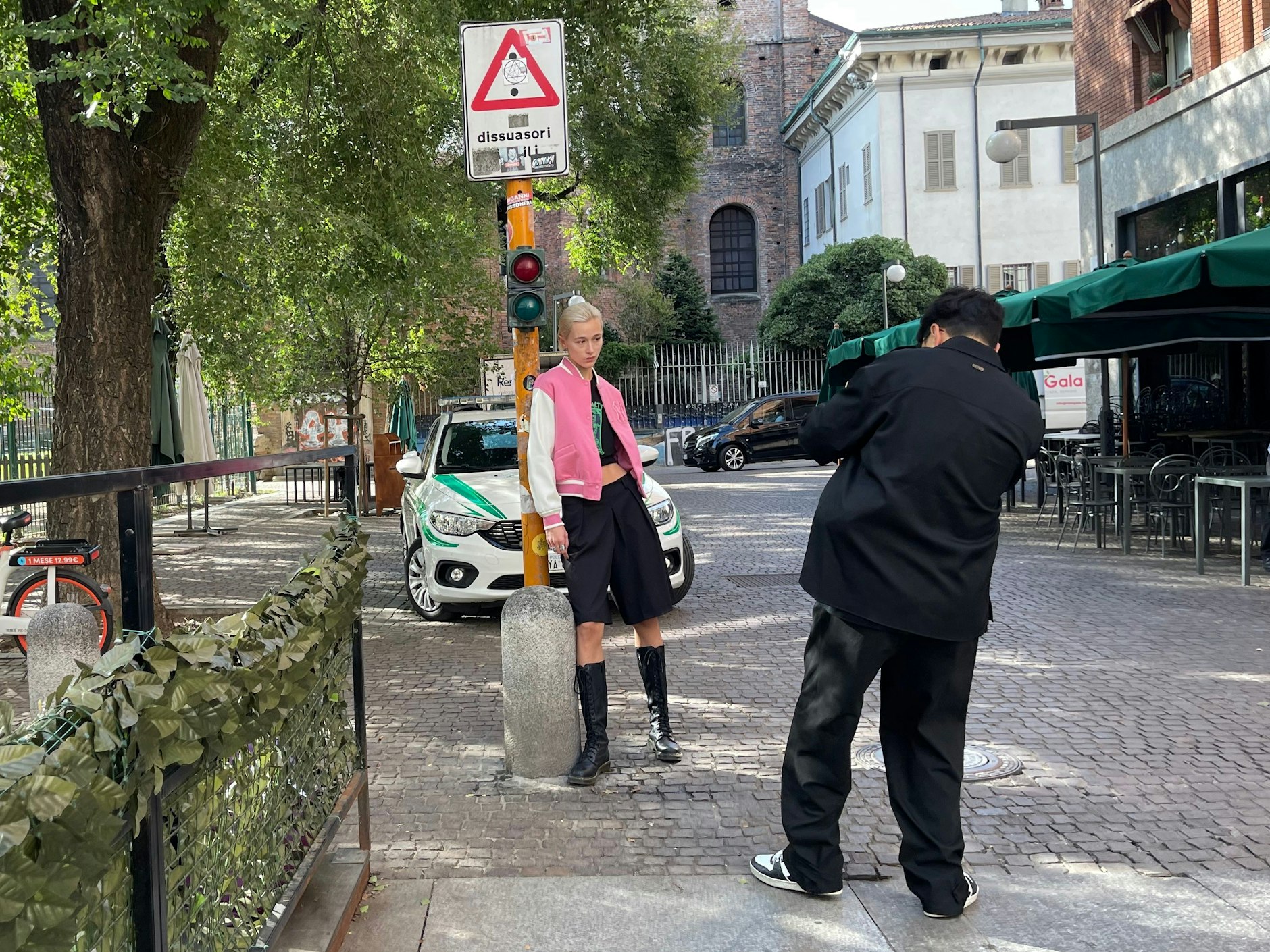 Posen am Warnschild; professionelle Influencer buchen Fotografen für die Fahion Week, um den perfekten Content zu haben.