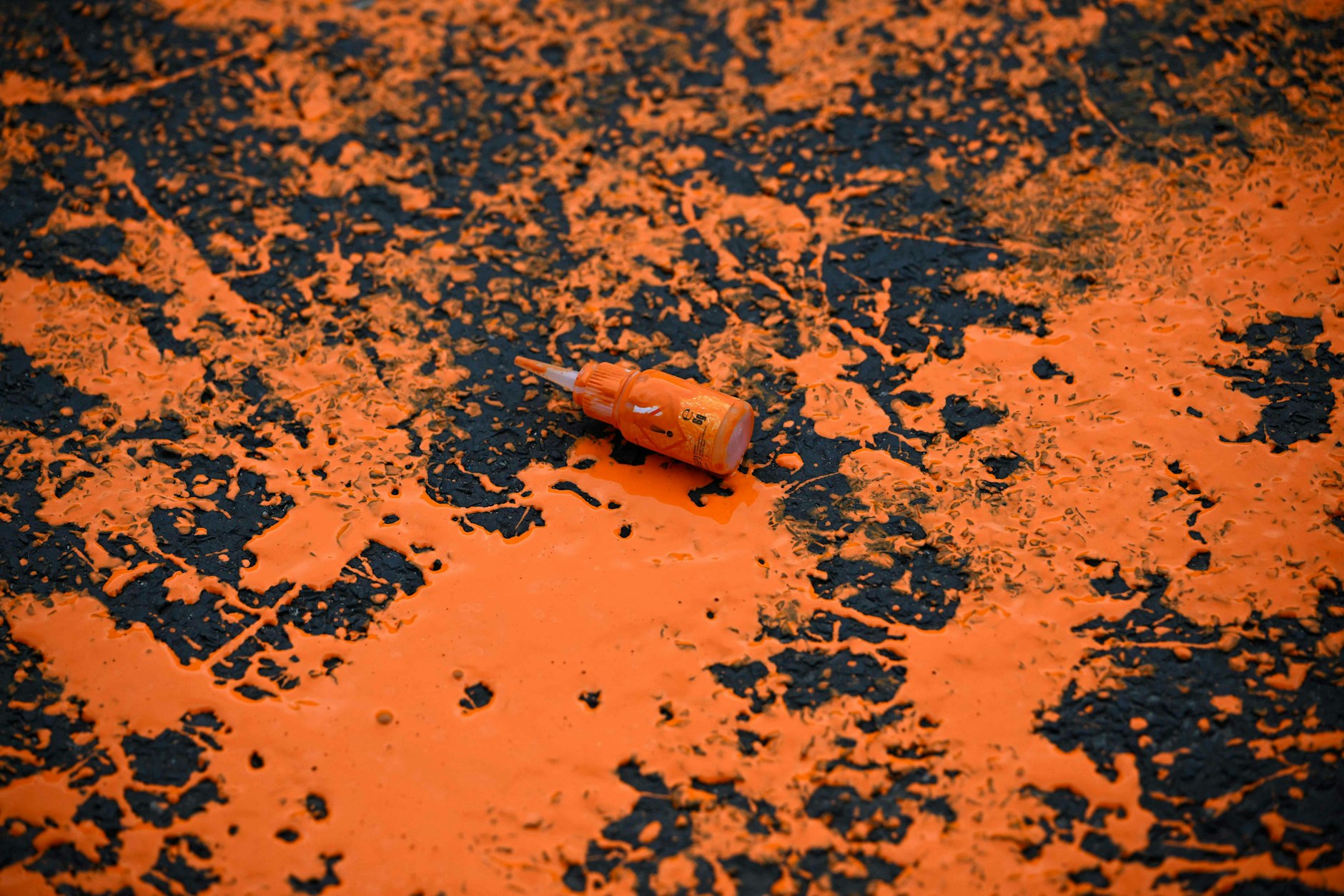 Orange Farbe, die von Klimaaktivisten der „Letzten Generation“ vor dem Berlin-Marathon auf die Strecke geschüttet wurde.