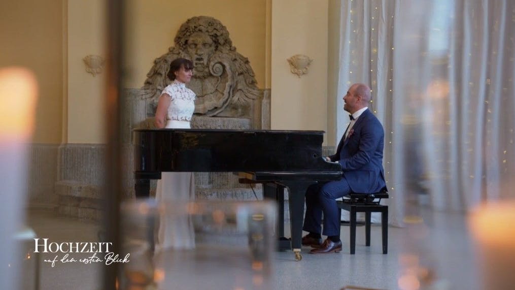 Nach der „Hochzeit auf den ersten Blick“ hat Bräutigam Heiko seine Braut Alex entführt, um ihr eine ganz besondere Überraschung zu bereiten: ein Ständchen auf dem Flügel.