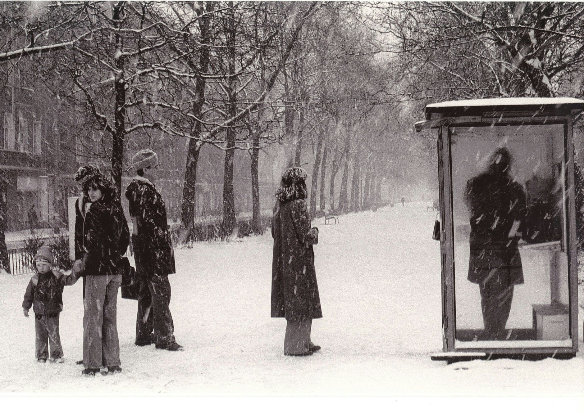 „Fasse Dich kurz“. Im Winter 1985/86 stehen Menschen auf dem Mittelstreifen der Warschauer Straße Schlange vor einem Telefonhäuschen.