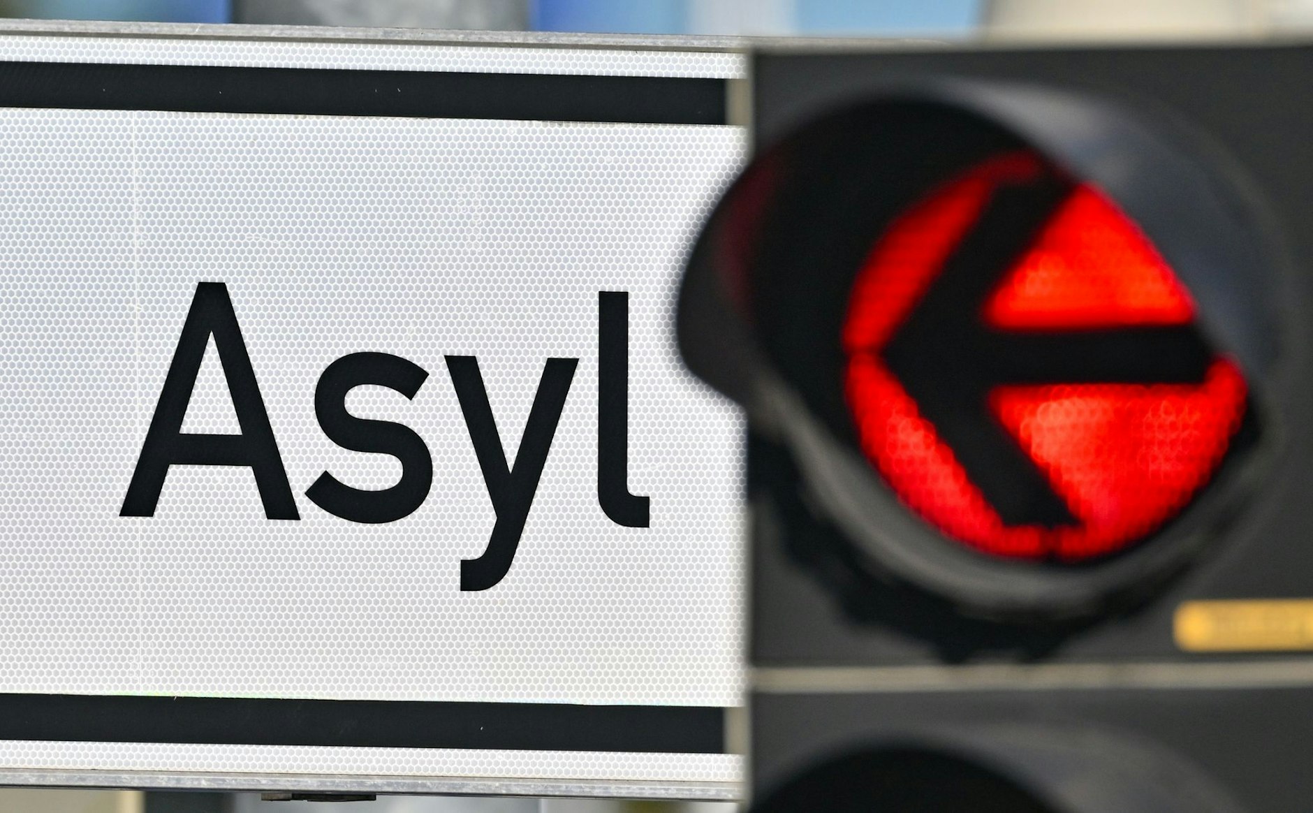 Eine rote Ampel leuchtet vor dem Wort «Asyl».  