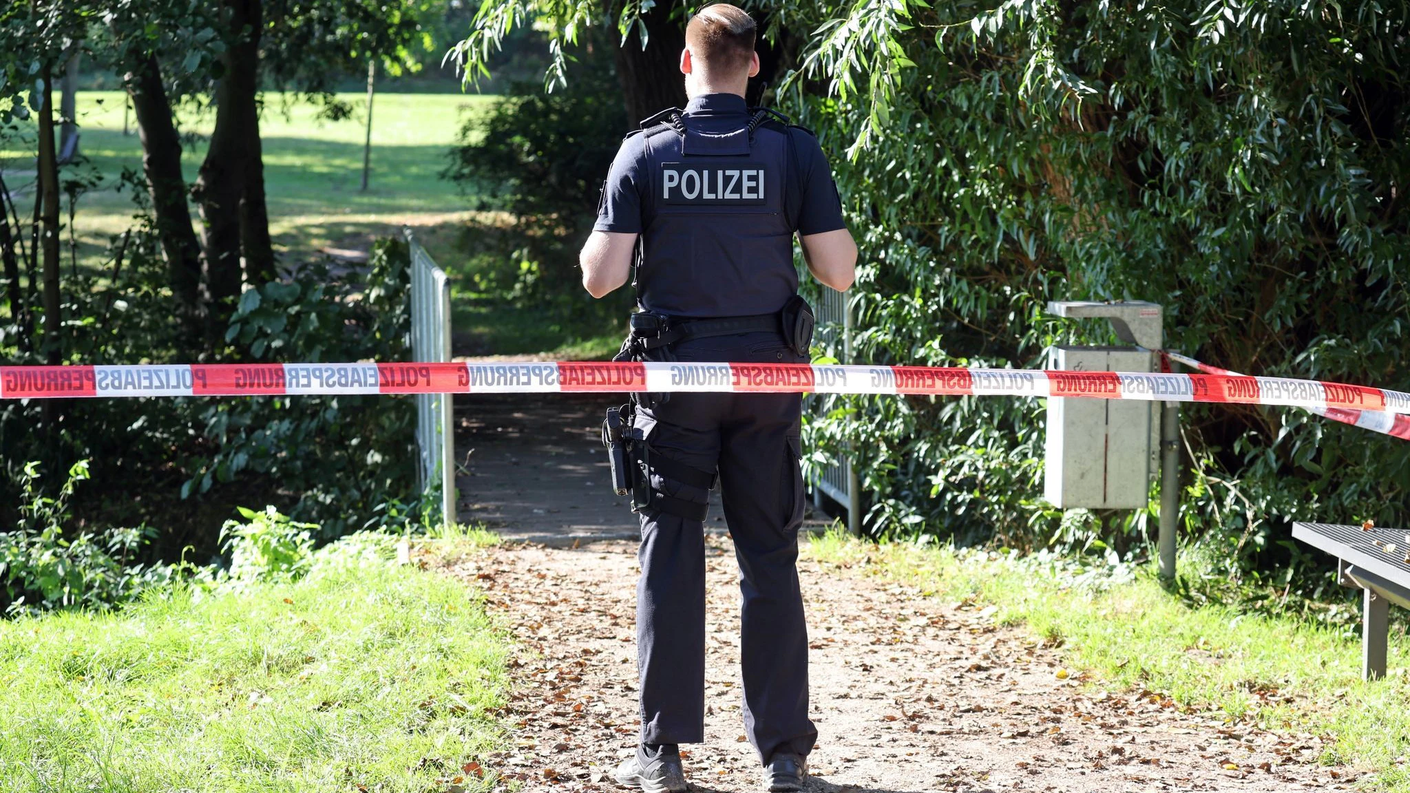 Ein Polizist sichert den abgesperrten Fundort der Leiche am See Pragsdorf ab.
