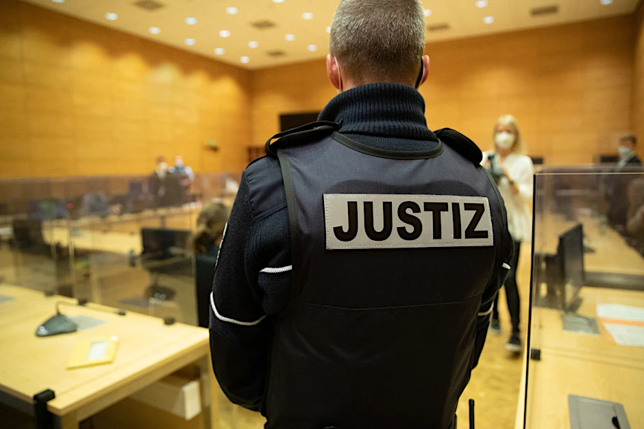 ARCHIV - Ein Justizbeamter steht in einem Gerichtssaal.  