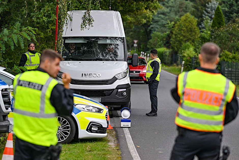 Polizeibeamte überprüfen einen Kleintransporter bei einer Kontrolle gegen Schleuserkriminalität.  