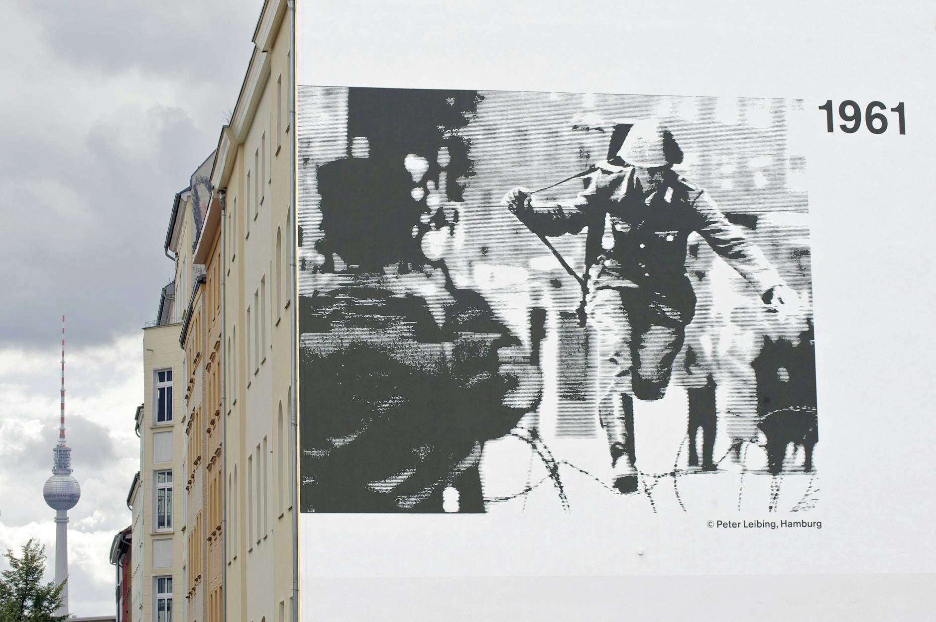 An der Bernauer Straße ist das berühmte Bild des Fotografen Peter Leibing auf eine Hauswand gemalt: Am 15. August 1961 springt der 19jährige DDR-Soldat Conrad Schumann.