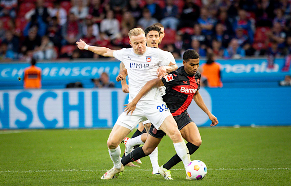 Lennard Maloney (l., hier gegen Leverkusens Amine Adli) spielte einst beim 1. FC Union Berlin, schaffte aber erst in Heidenheim den Sprung in die Bundesliga.
