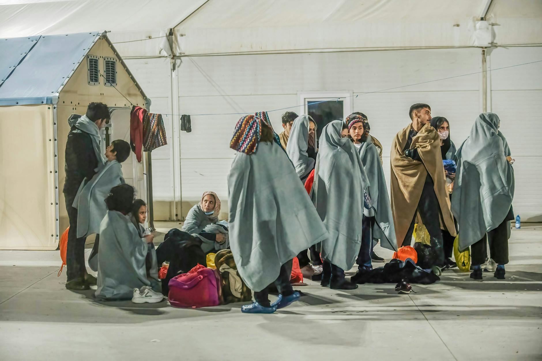 Geflüchtete sind in einem Erste-Hilfe-Camp in Italien zu sehen. Patrouillenboote der italienischen Küstenwache hatten sie zuvor aufgegriffen.