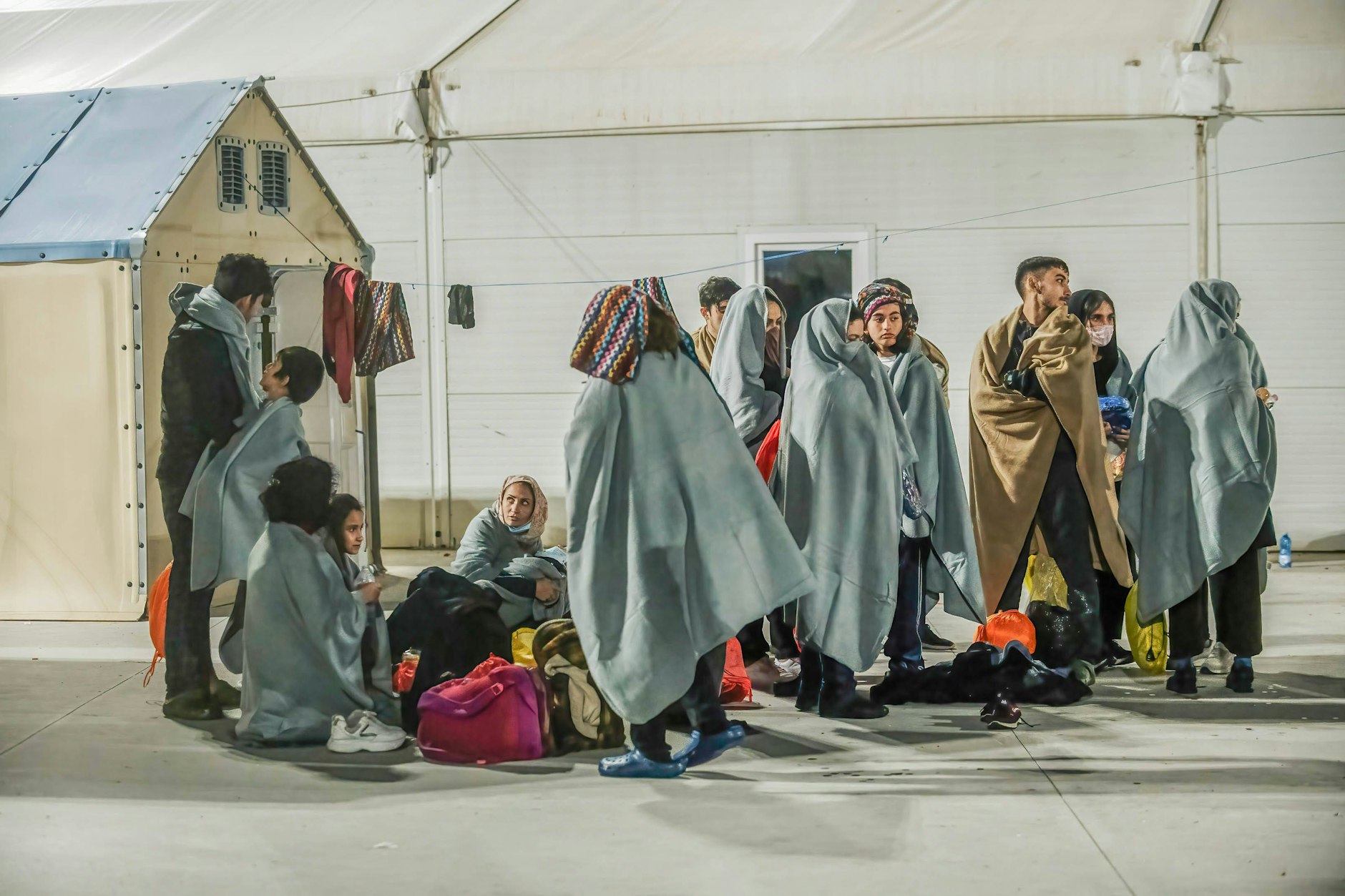 Geflüchtete sind in einem Erste-Hilfe-Camp in Italien zu sehen. Patrouillenboote der italienischen Küstenwache hatten sie zuvor aufgegriffen.