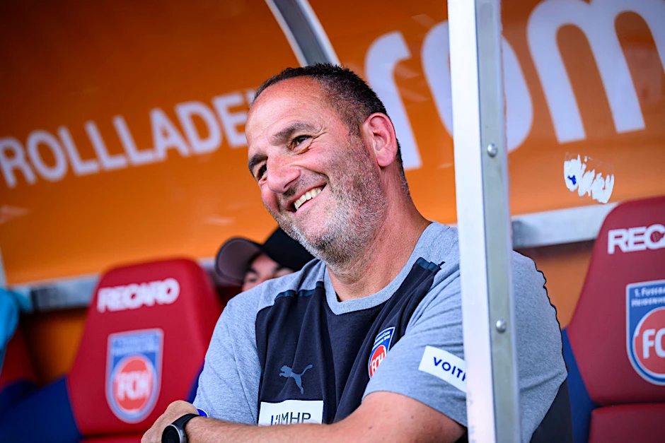 ARCHIV - Heidenheims Trainer Frank Schmidt sitzt vor dem Spiel auf der Trainerbank.  
