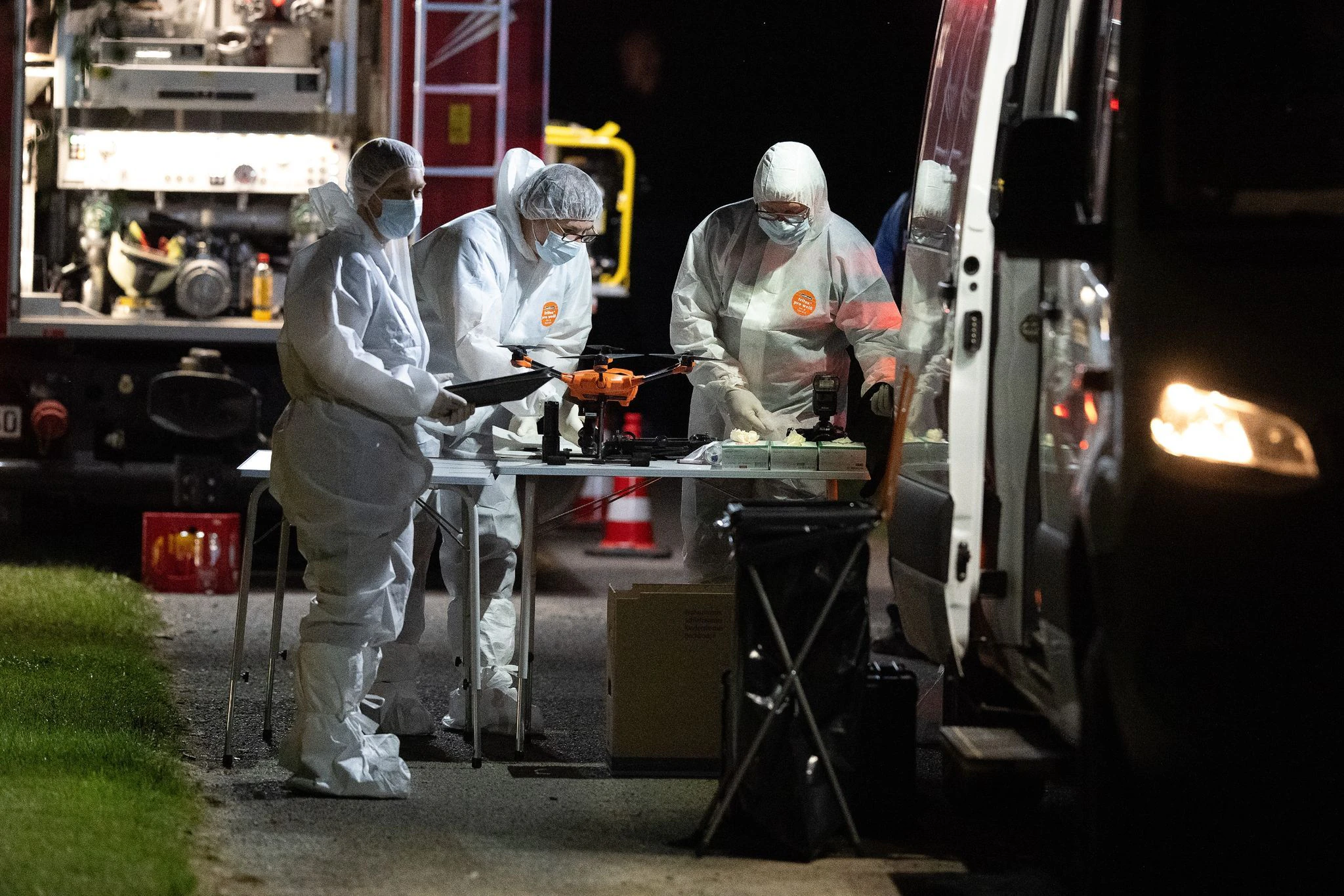 Mitarbeiter der Spurensicherung stehen nach dem Fund der Leiche an ihren Einsatzfahrzeugen.  