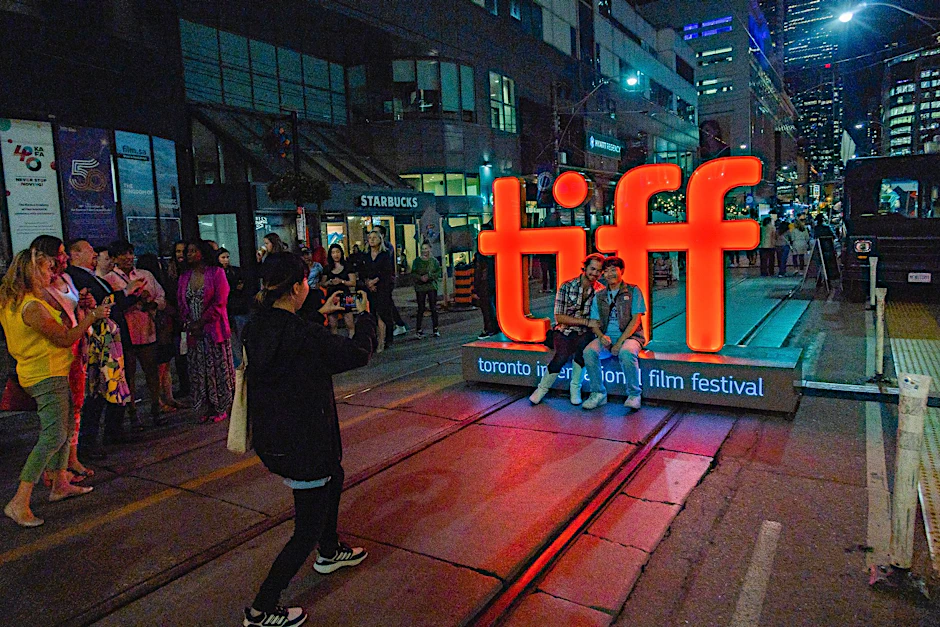 Menschen machen Fotos vor einer Leuchtreklame vor der TIFF Bell Lightbox während des 48. Toronto International Film Festivals.  