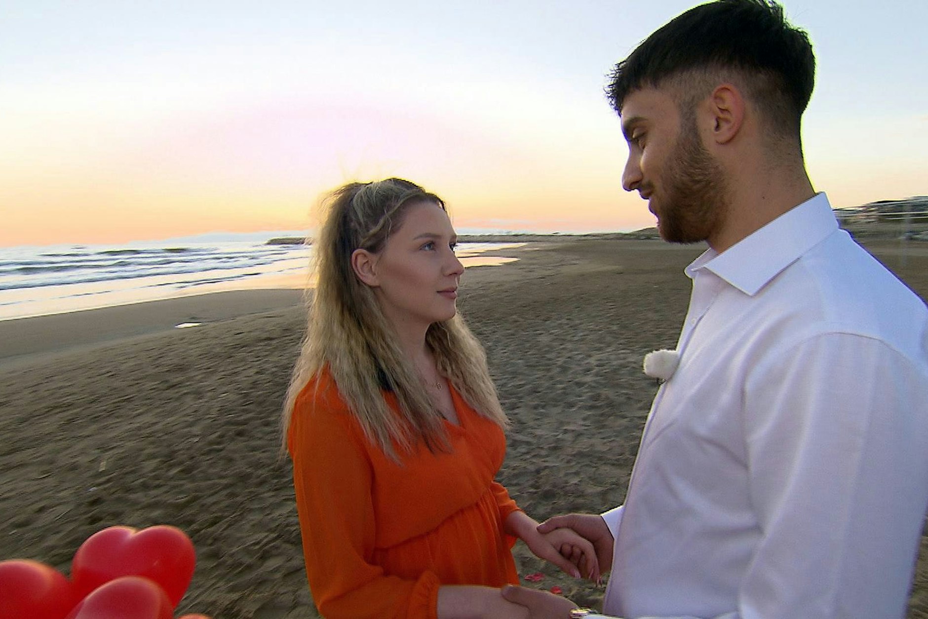 Servet hält am Strand um Loredanas Hand an.