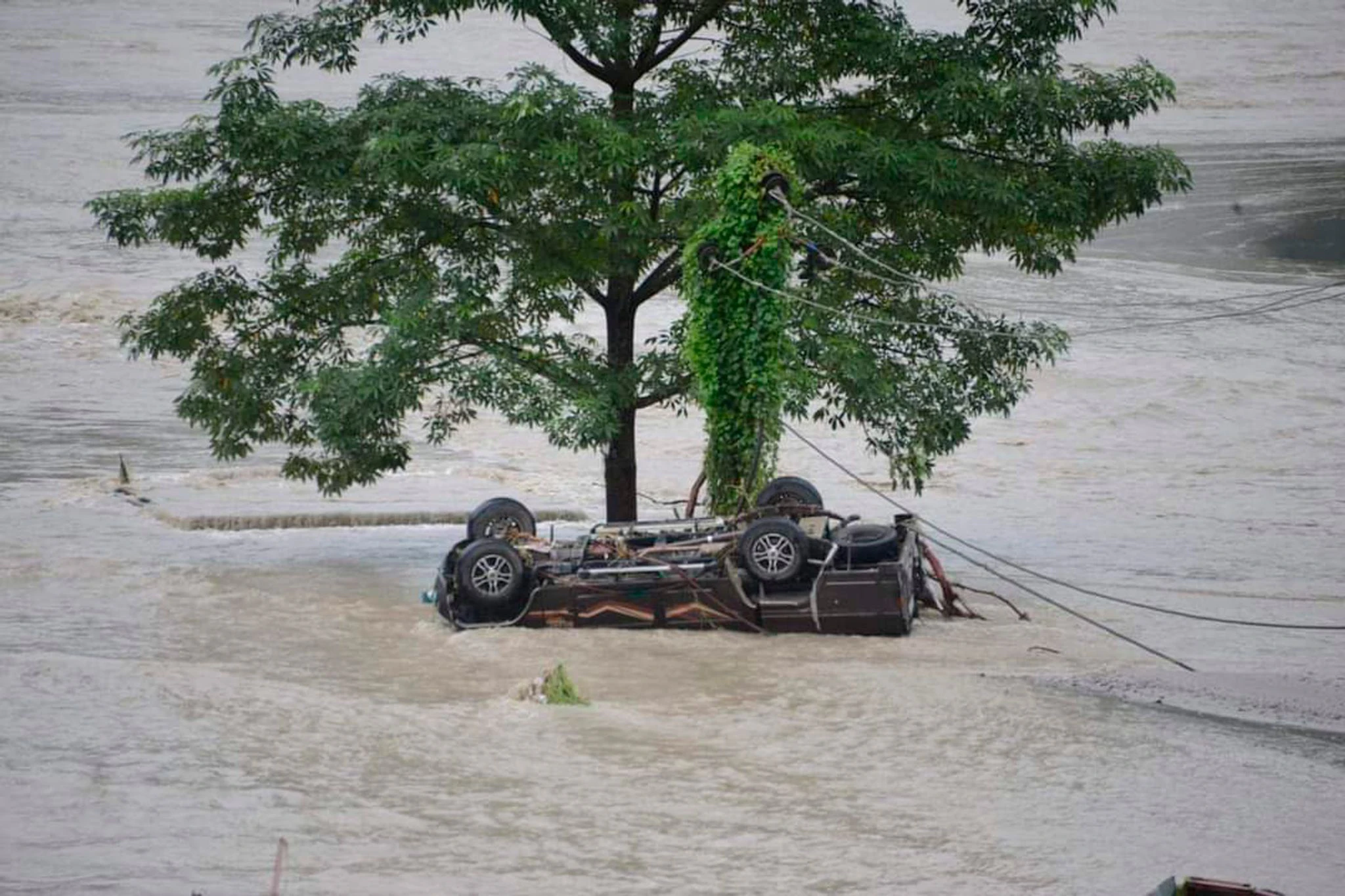 Nach starken Regenfällen ist der Fluss Teesta im Nordosten Indiens über die Ufer getreten und hat Dörfer überschwemmt und eine Autobahn beschädigt. Dieses Auto wurde mitgerissen.  