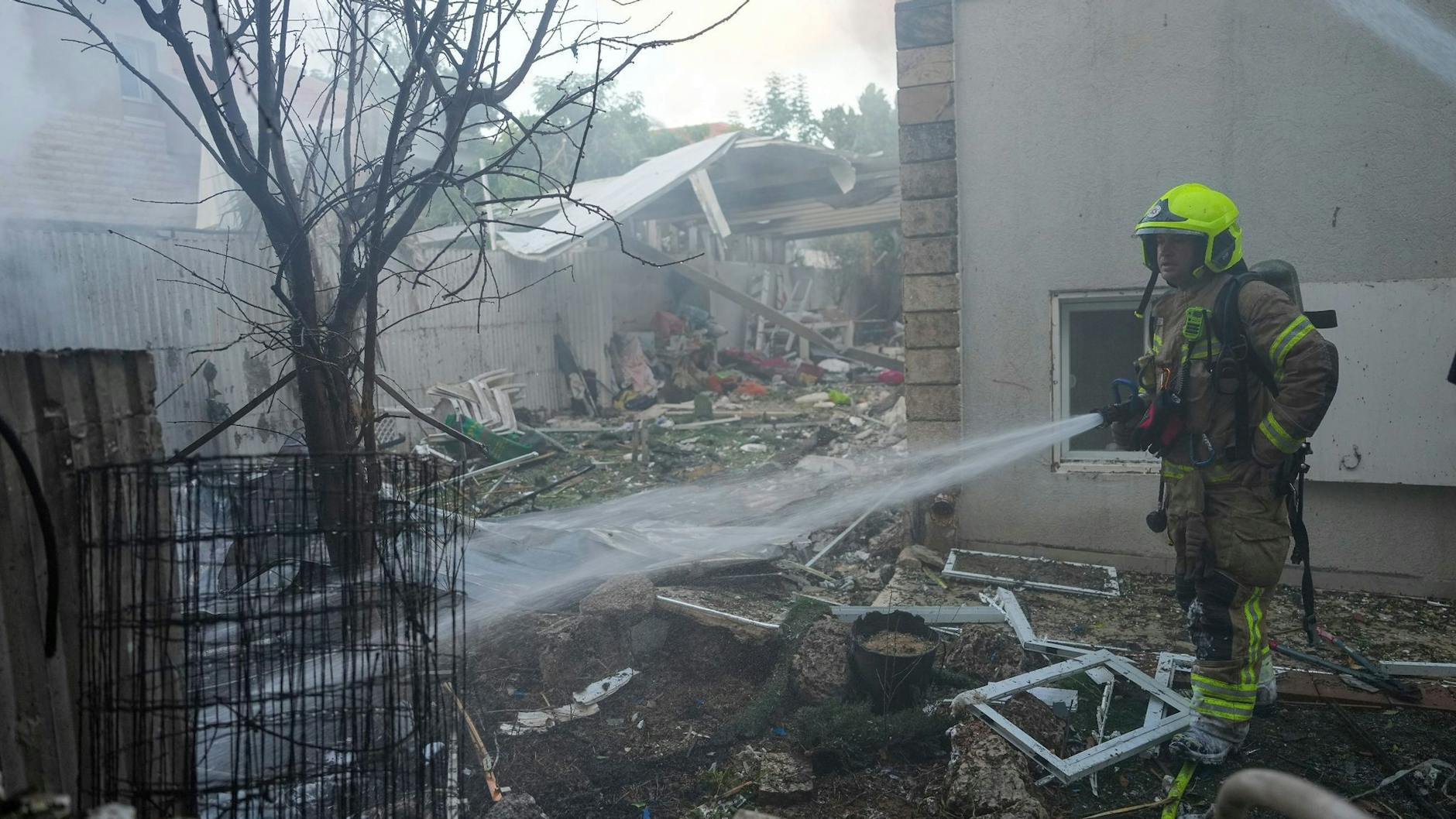 Israelische Feuerwehrleute löschen ein Feuer, nachdem eine aus dem Gazastreifen abgefeuerte Rakete ein Haus im Süden Israels getroffen hat.