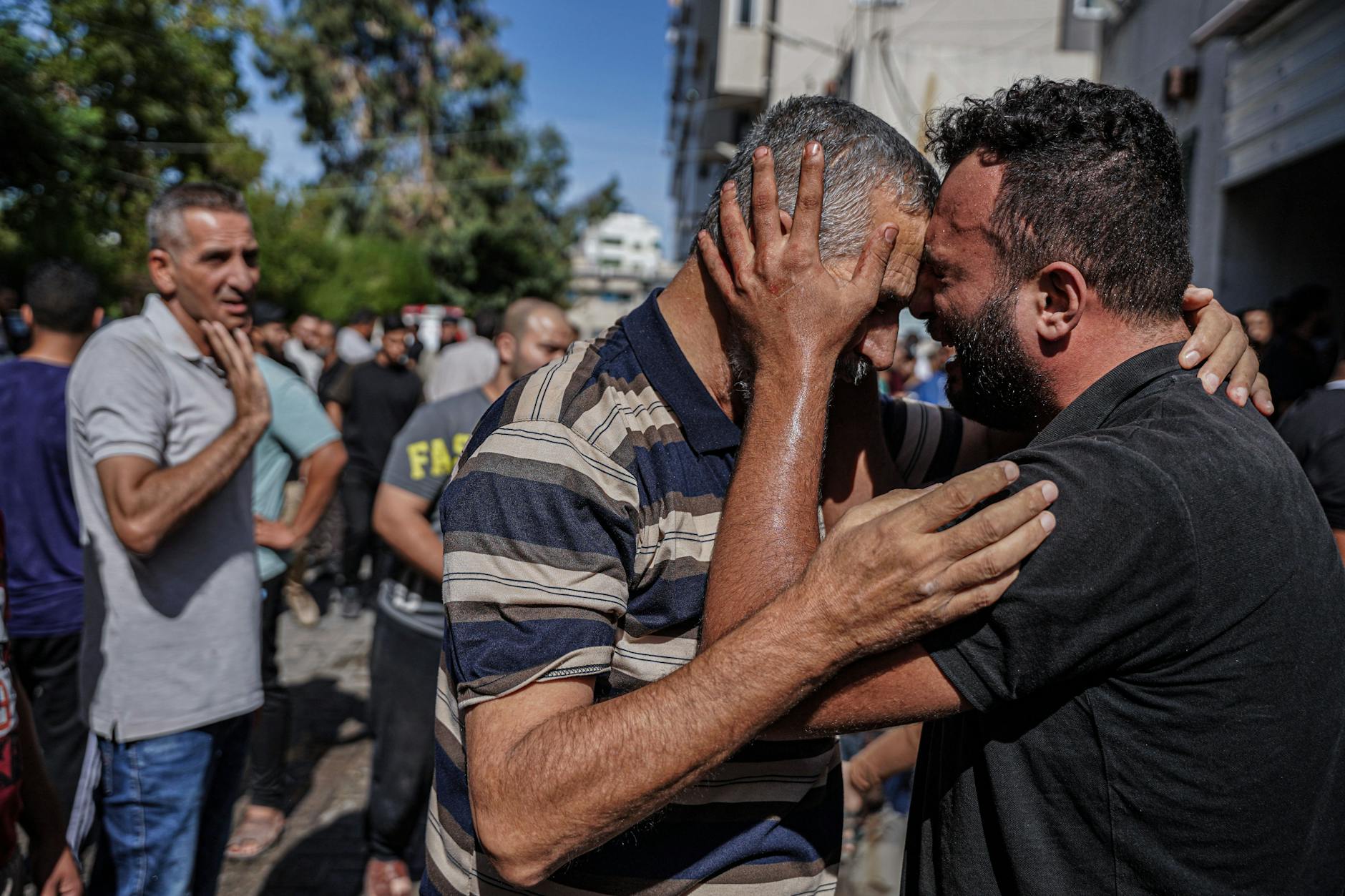 Ein Mann umarmt einen Familienangehörigen im palästinensischen Gebiet und weint.