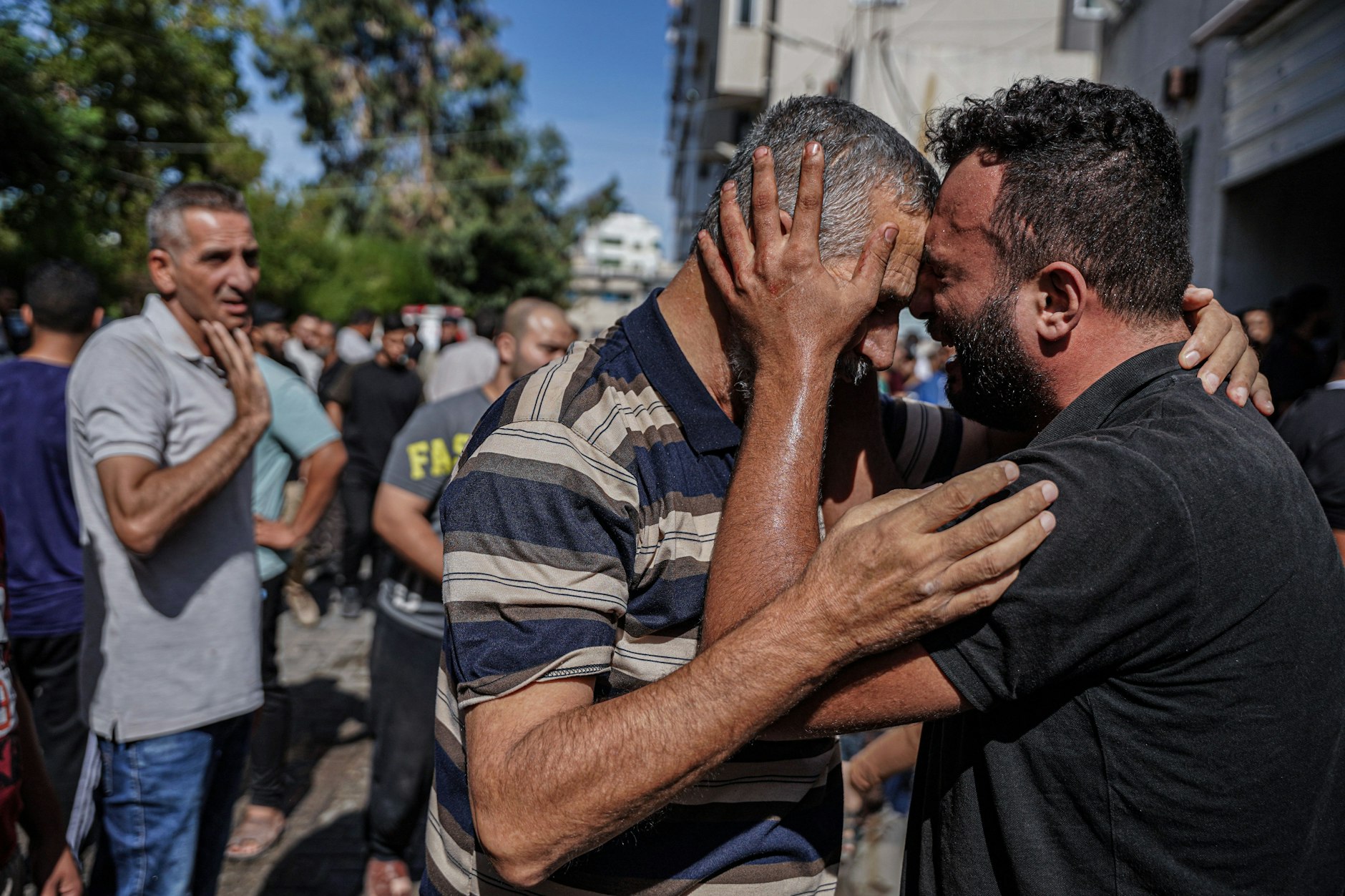 Ein Mann umarmt einen Familienangehörigen im palästinensischen Gebiet und weint.