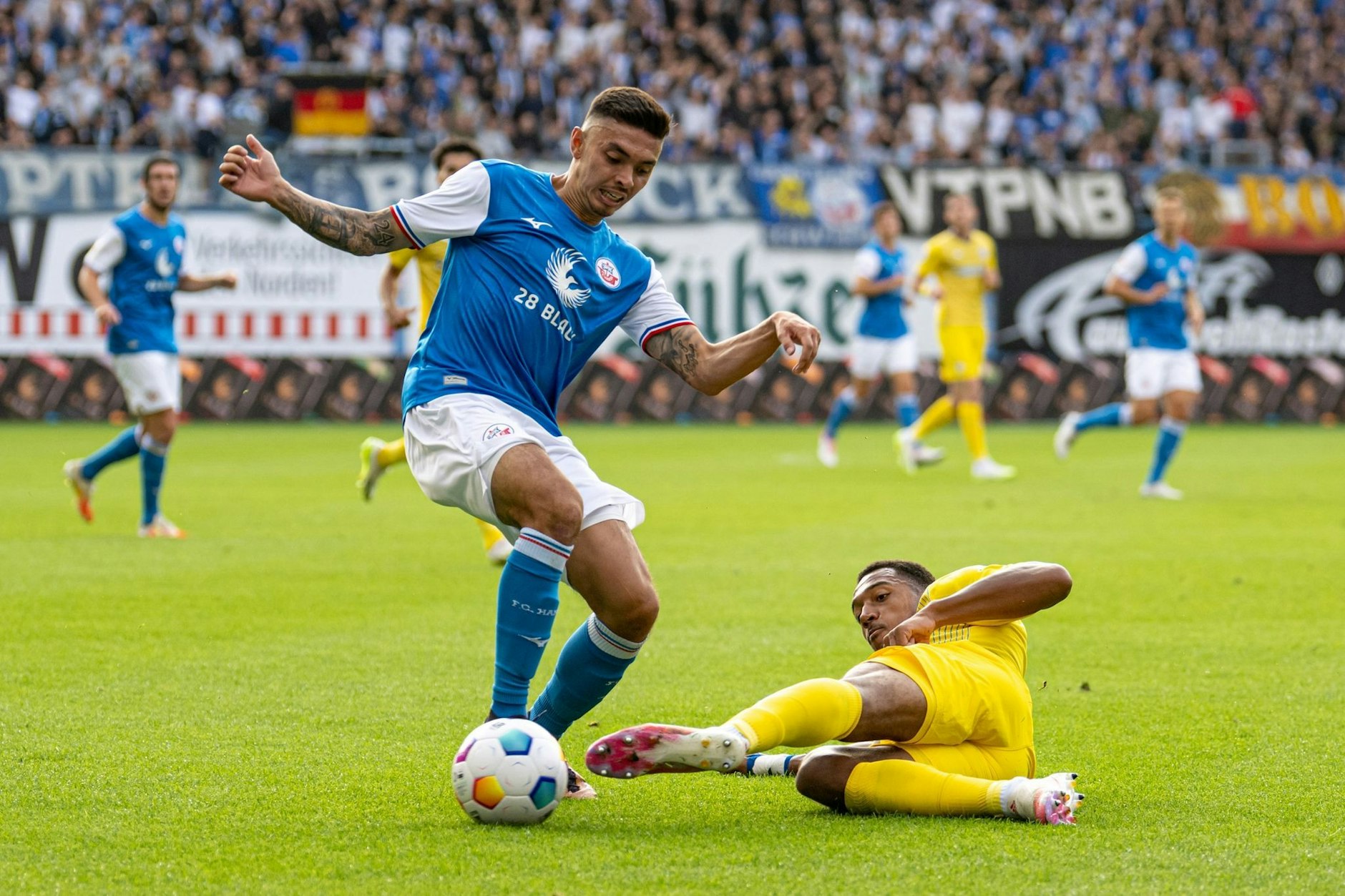 Die Rostocker um John-Patrick Strauß (l) setzten sich gegen Anton Donkor und Eintracht Braunschweig durch.  