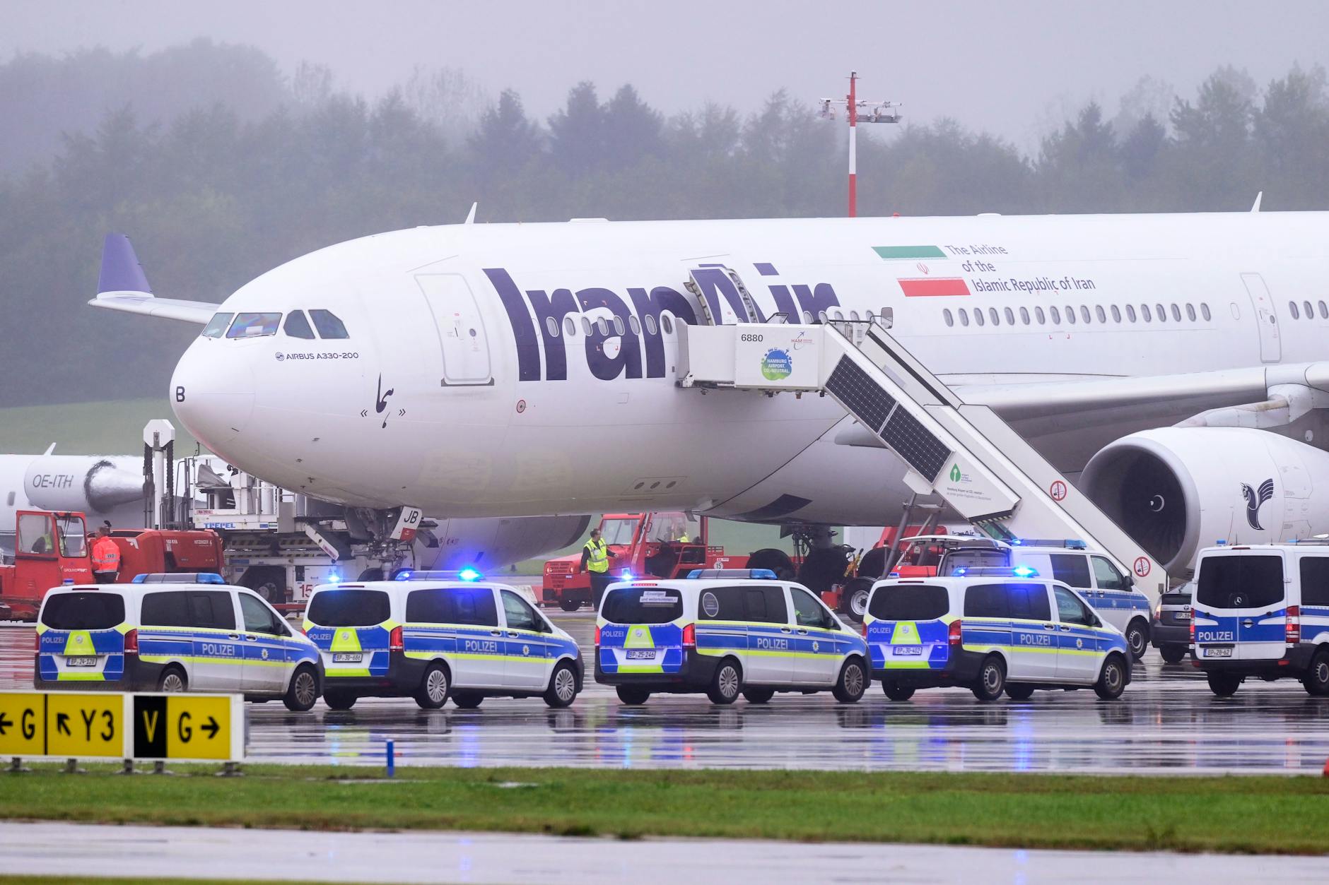 Einsatzfahrzeuge der Polizei stehen vor einem Flugzeug der Iran Air mit dem Kennzeichen EP-IJB auf dem Flughafen Hamburg.