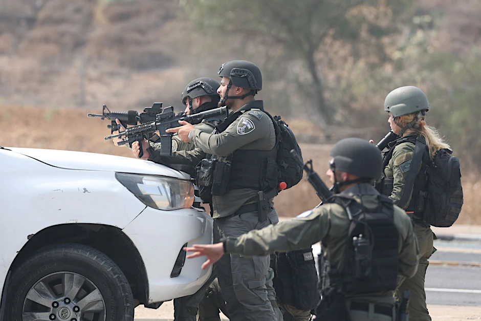 Israelische Streitkräfte gehen hinter einem Fahrzeug in Sderot in Stellung.  
