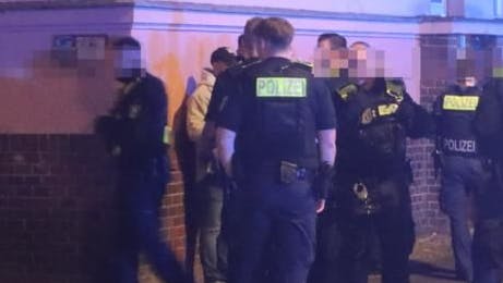 Polizisten verhören Tatverdächtige, die Hetz-Parolen gesprüht haben sollen.