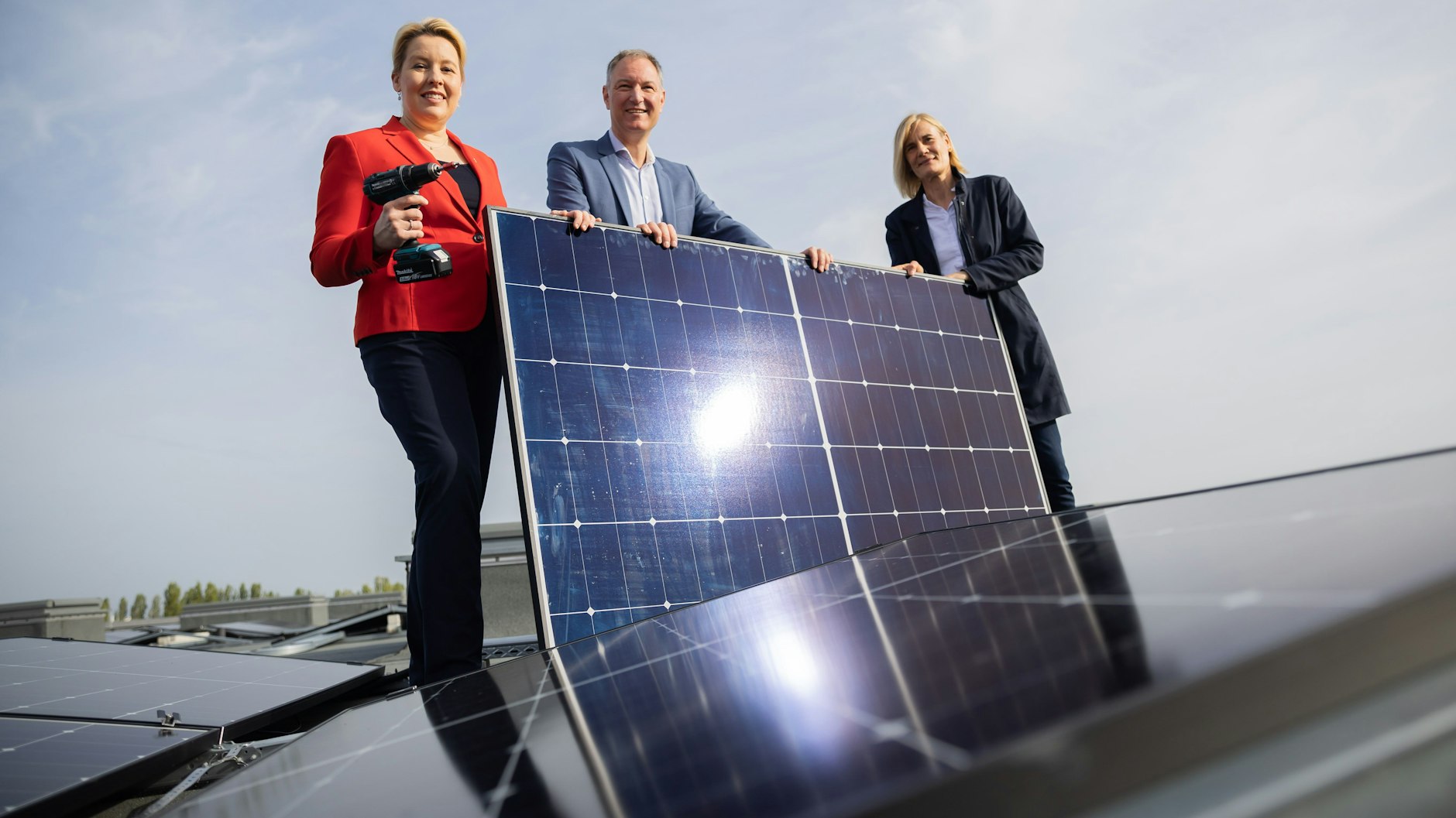 Wirtschaftssenatorin Franziska Giffey, Messe-Chef Mario Tobias und Stadtwerke-Chefin Kerstin Busch mit einem Solarpanel auf dem Dach der Messe Berlin.&nbsp;