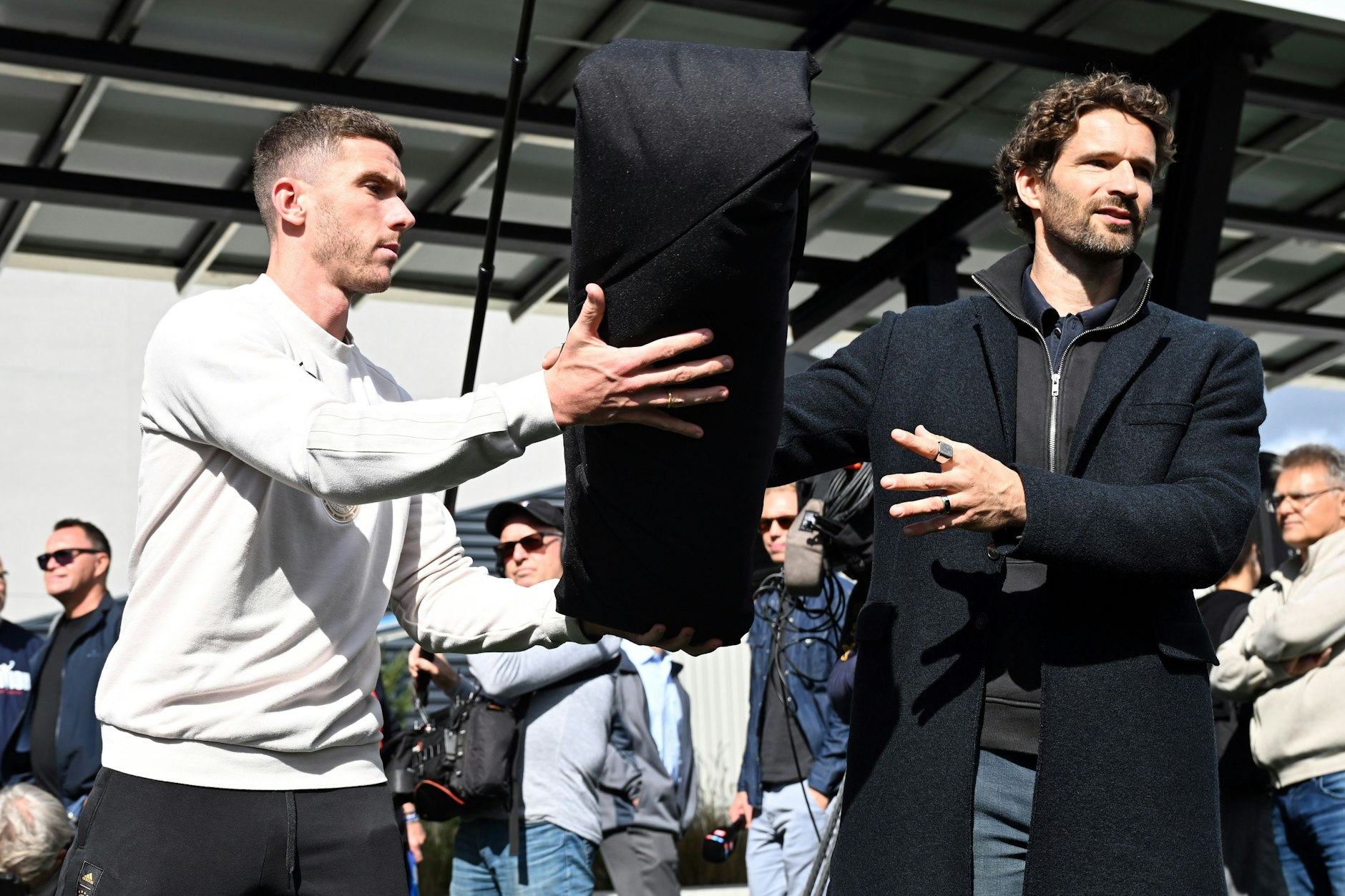 Union-Star Robin Gosens und Hertha-Legende Arne Friedrich (r.) laden in den USA Hilfspakete für Obdachlose in einen Lieferwagen.